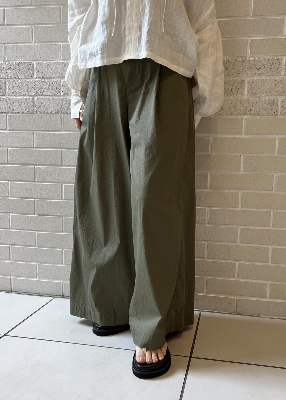 ホワイト系のサンダル、ベージュ系のTシャツ/カットソー、ホワイト系のシャツ/ブラウスを着用したレディースの春コーディネートの7枚目の写真