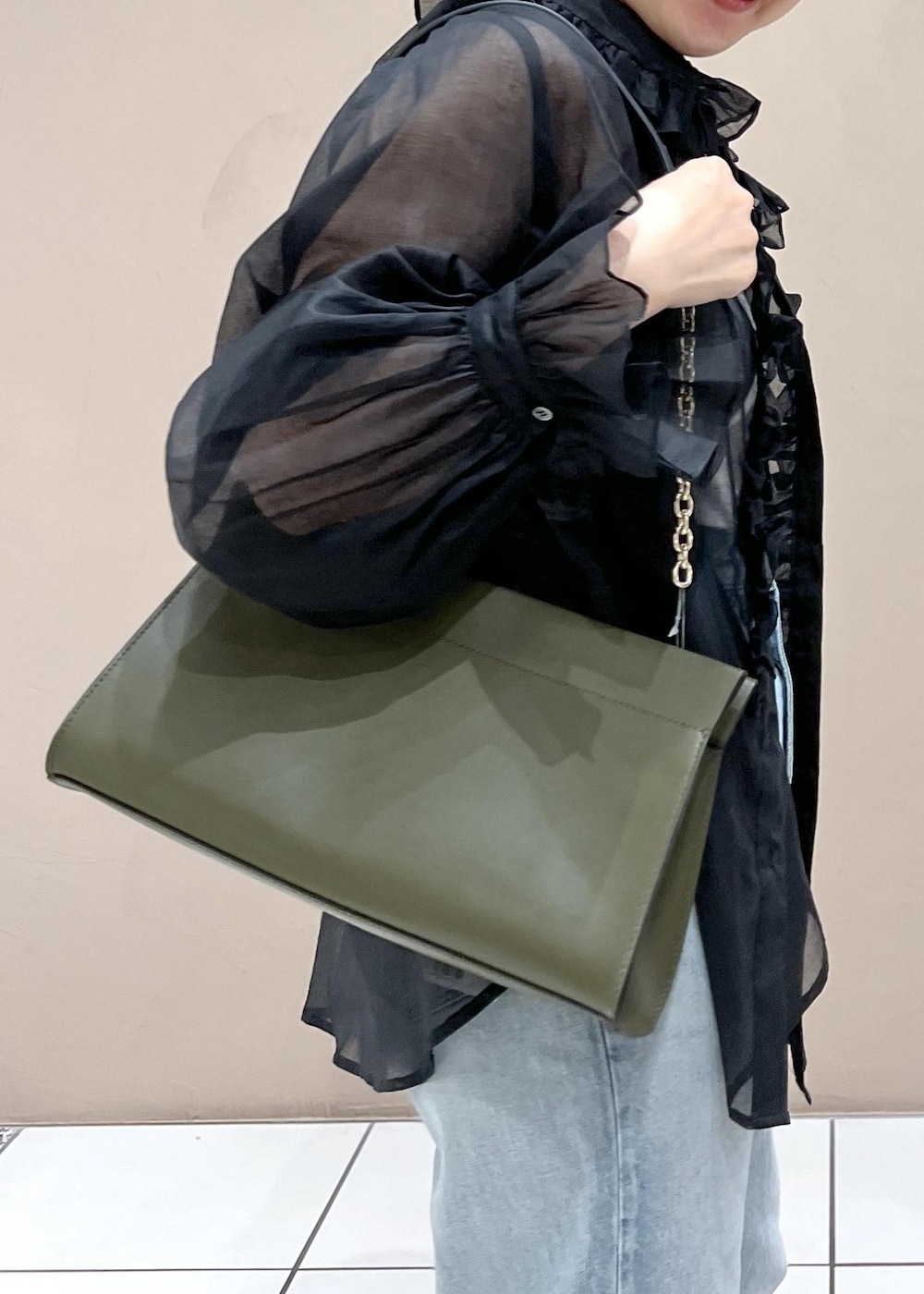 グリーン系のショルダーバッグ、ブルー系のデニムパンツ、ホワイト系のスニーカーを着用したレディースの夏コーディネートの8枚目の写真