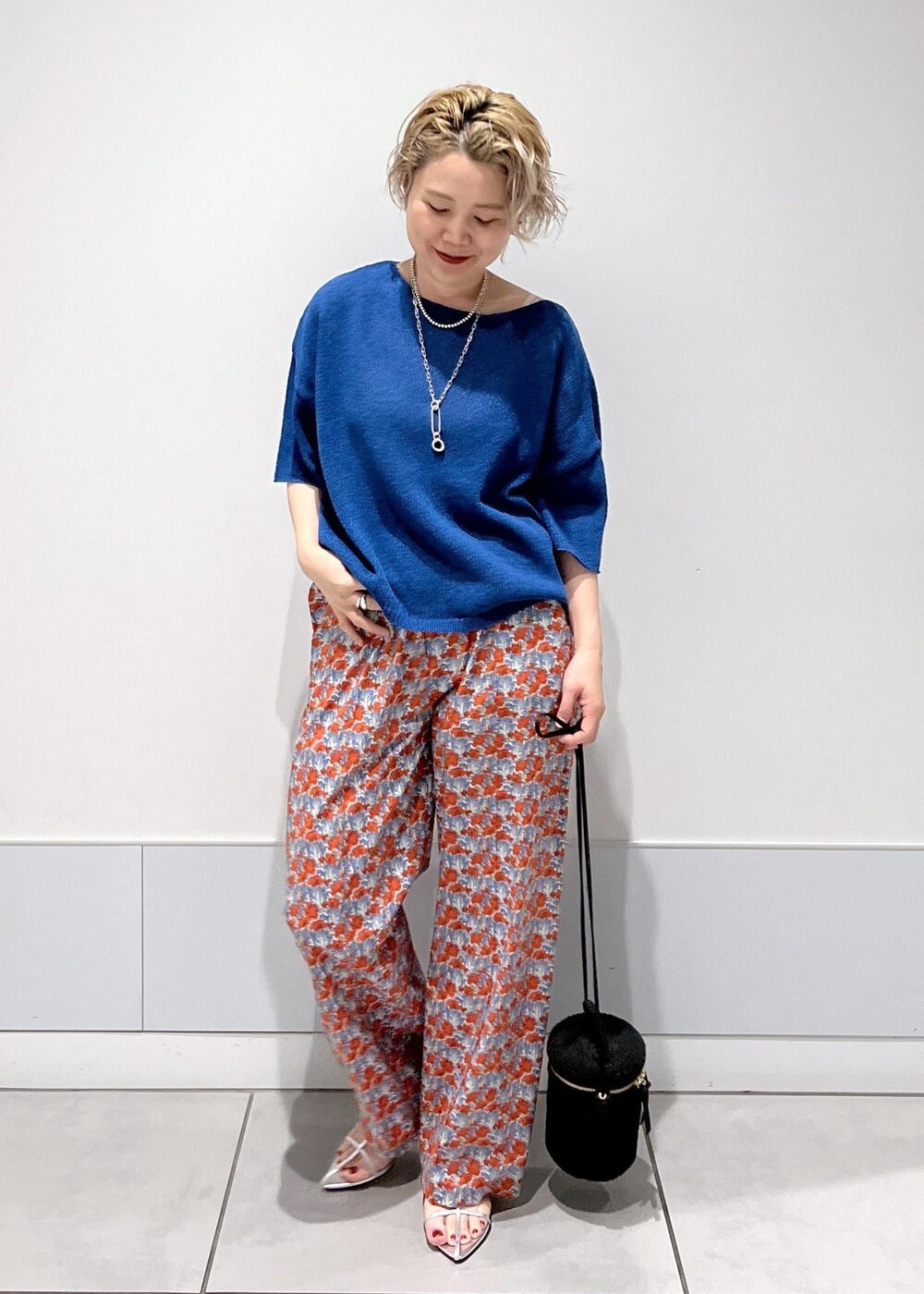 シルバー系のサンダル、ブラック系のショルダーバッグ、ブルー系のその他パンツを着用したレディースの夏コーディネートの2枚目の写真