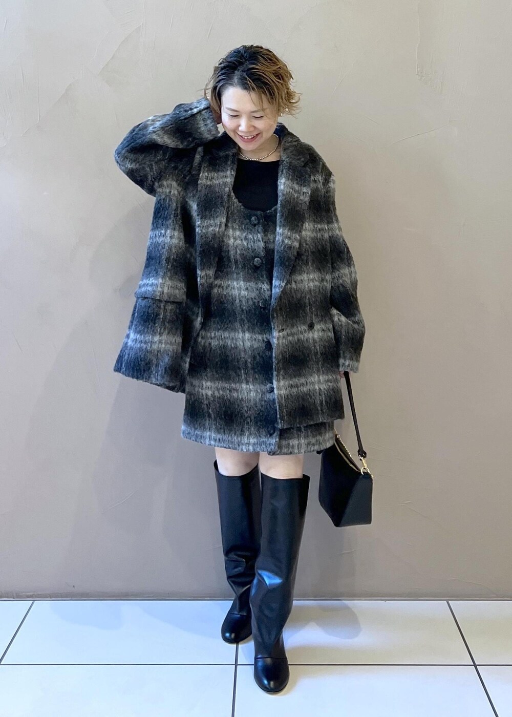 グレー系のジャンパースカート、グレー系のその他アウター、ブラック系のTシャツ/カットソーを着用したレディースの秋コーディネートの2枚目の写真