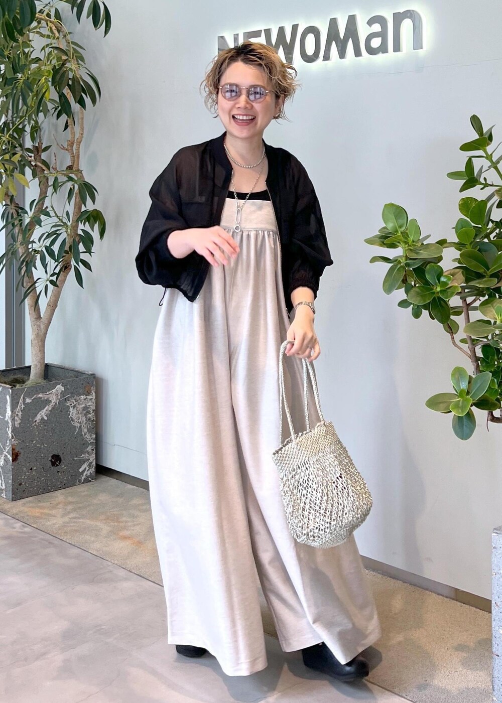 ブラック系のブルゾン、ブラック系のタンクトップ、シルバー系のトートバッグを着用したレディースの春コーディネートの4枚目の写真