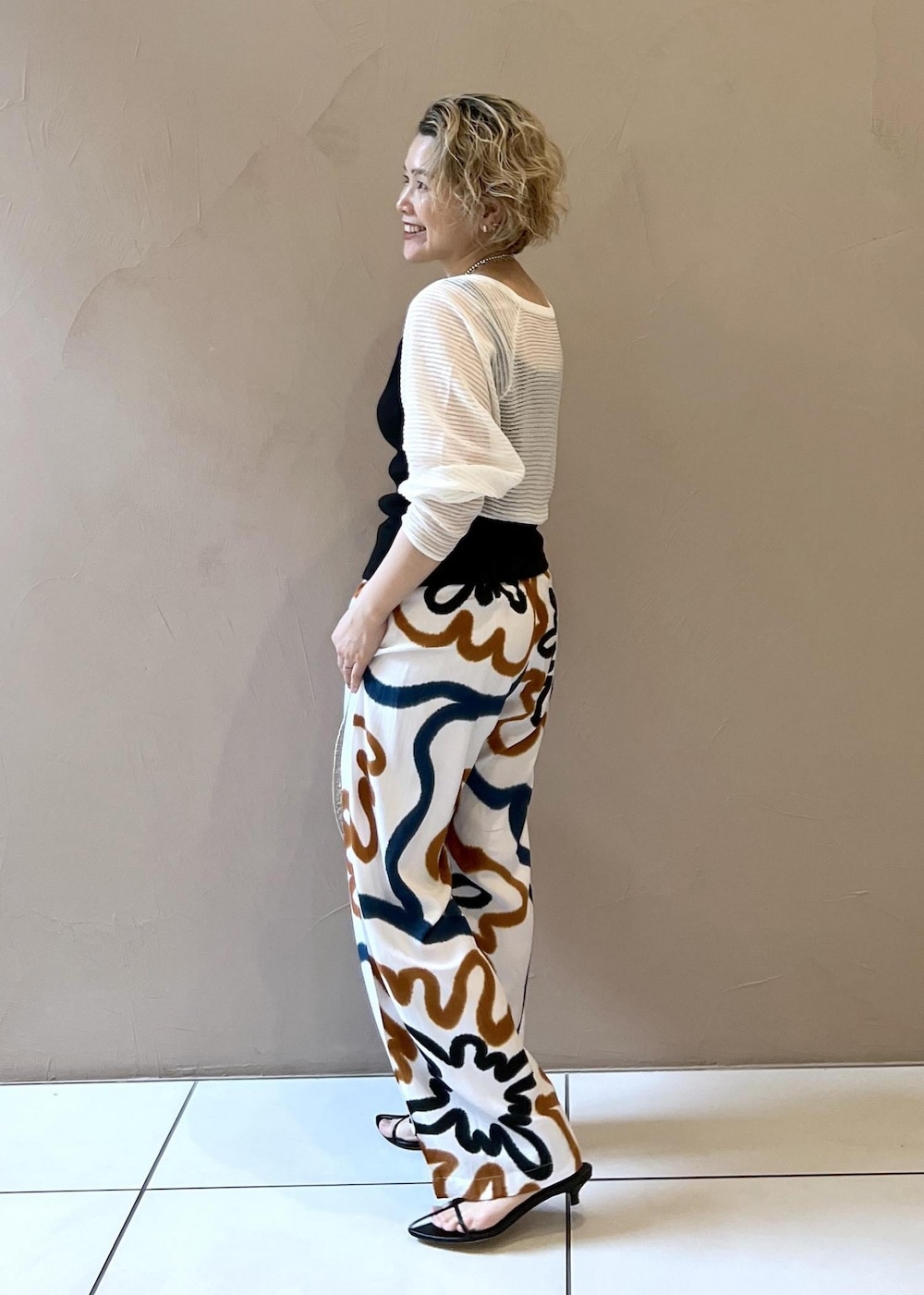 ブラック系のサンダル、ブラック系のタンクトップ、ホワイト系のカーディガン/ボレロを着用したレディースの春コーディネートの4枚目の写真