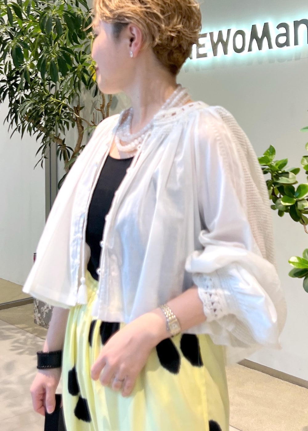 ブラック系のショルダーバッグ、ホワイト系のシャツ/ブラウス、ホワイト系のサンダルを着用したレディースの夏コーディネートの6枚目の写真