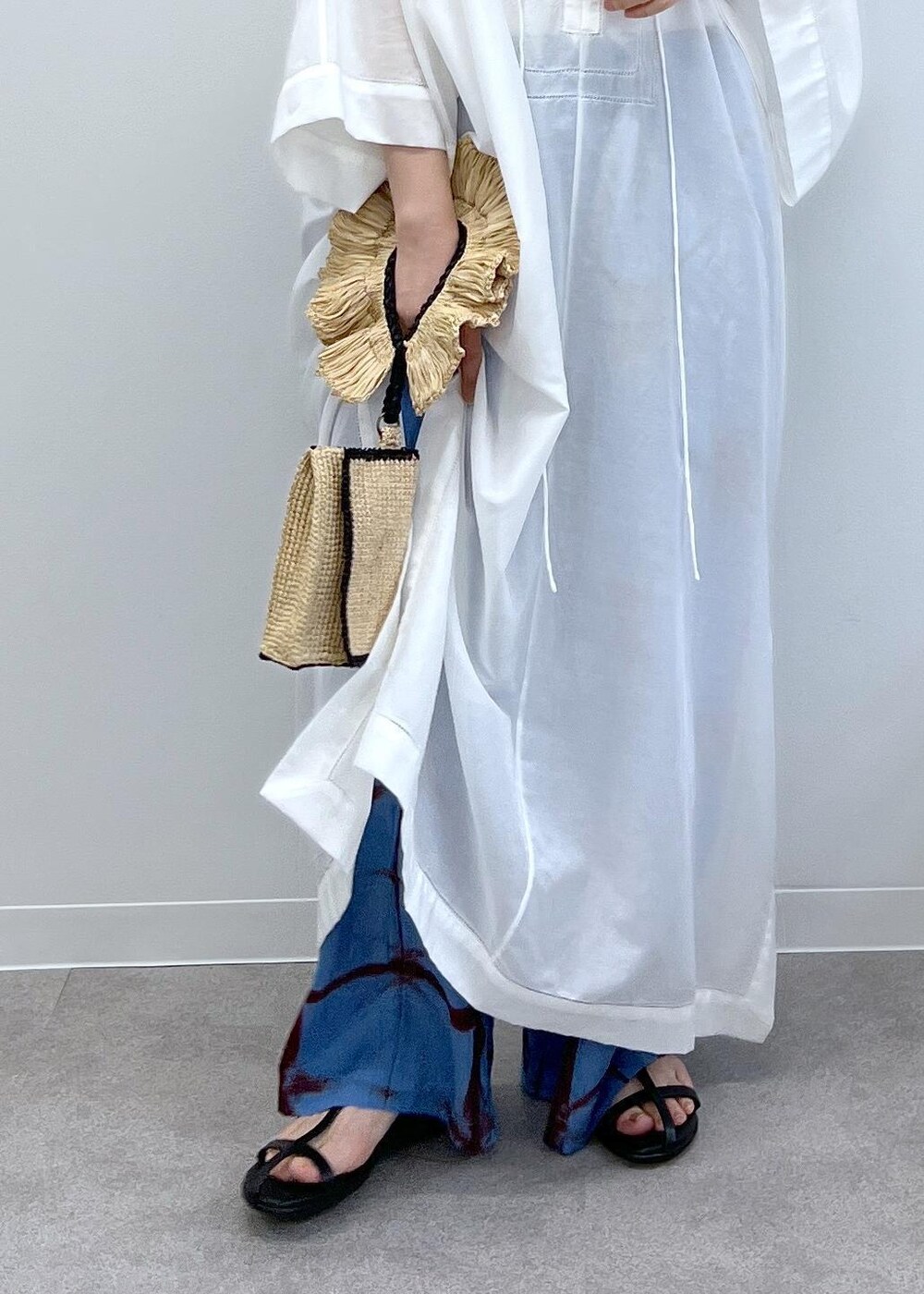 ブラック系のサンダル、ホワイト系のワンピース、ブルー系のその他パンツを着用したレディースの春コーディネートの8枚目の写真