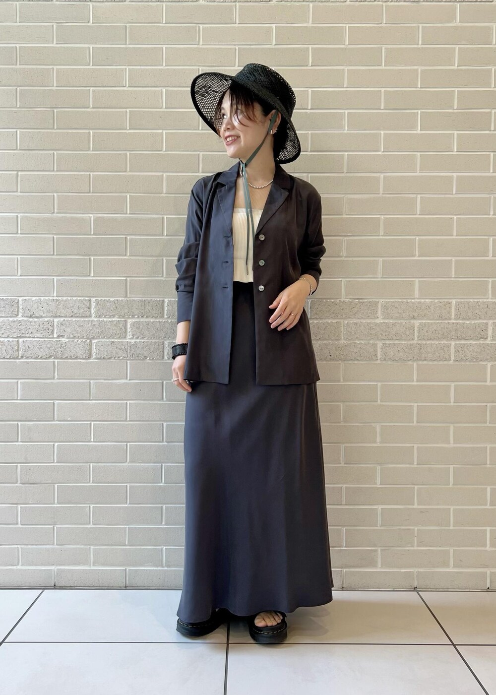 グレー系のスカート、グレー系のシャツ/ブラウス、ホワイト系のチューブトップを着用したレディースの春コーディネートの4枚目の写真