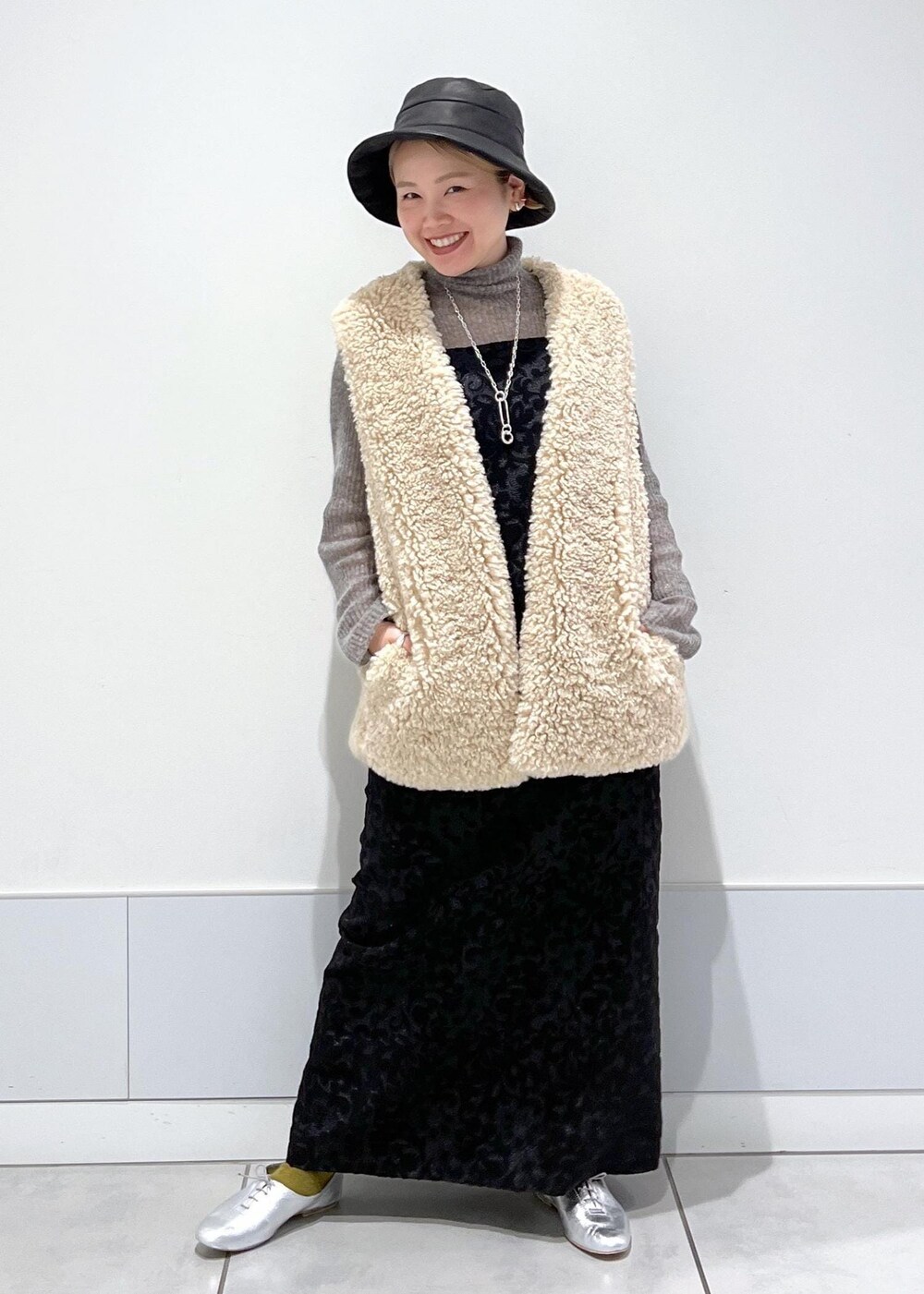 ベージュ系のベスト、ブラック系のワンピース、グレー系のニット/セーターを着用したレディースの秋コーディネートの4枚目の写真