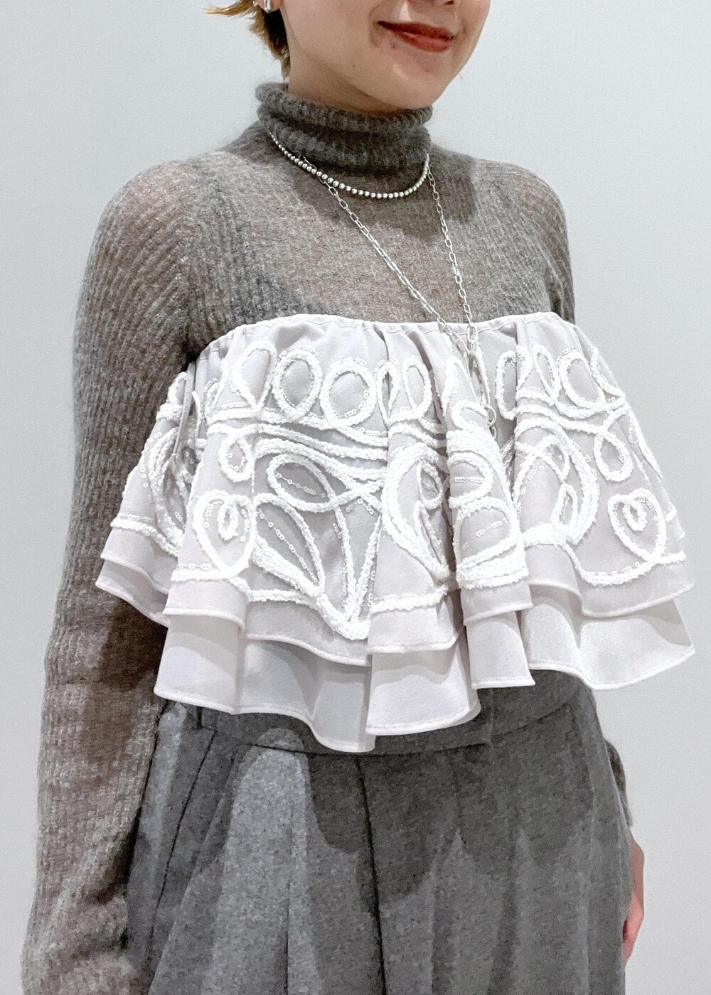 ブラック系のブーツ、グレー系のニット/セーター、ベージュ系のストール/ショールを着用したレディースの冬コーディネートの9枚目の写真