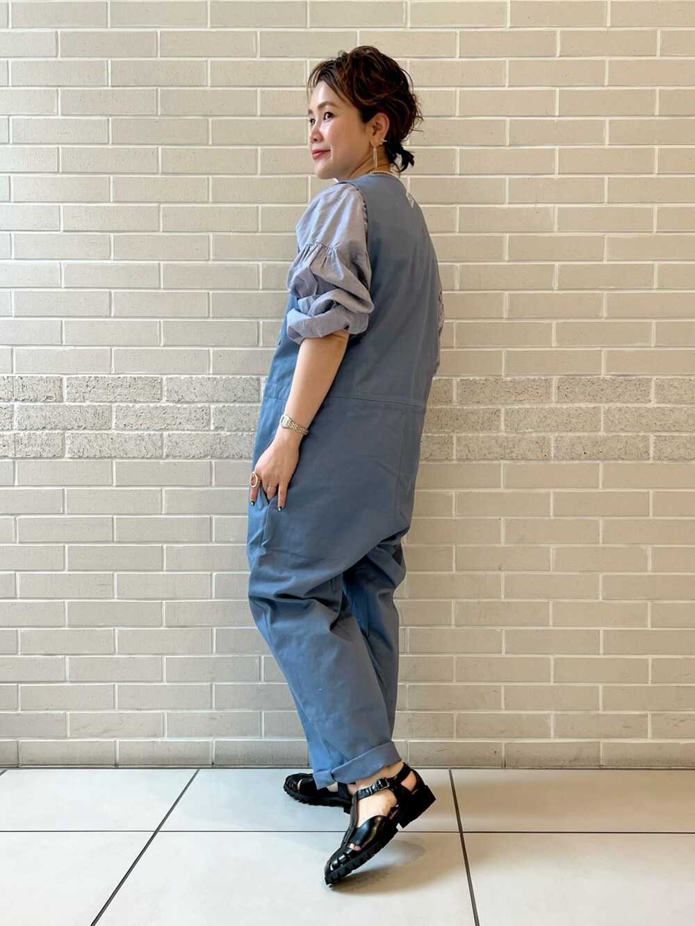ベージュ系のつなぎ/オールインワン、ブルー系のシャツ/ブラウス、ブラック系のサンダルを着用したレディースの春コーディネートの3枚目の写真