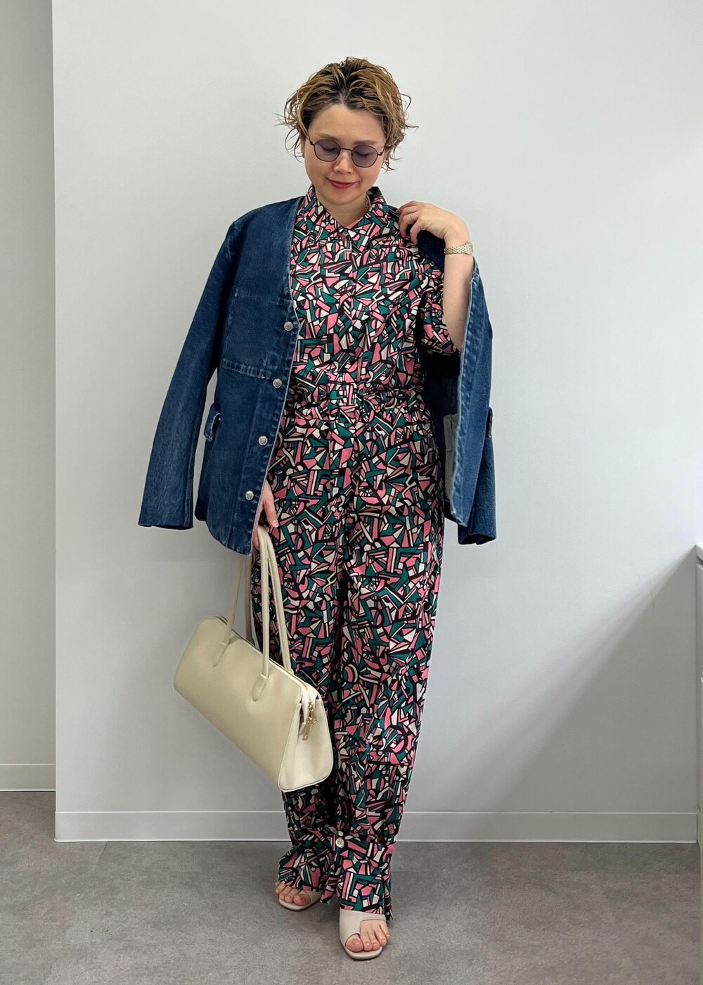 ホワイト系のボストンバッグ、グレー系のサンダル、グリーン系のつなぎ/オールインワンを着用したレディースの春コーディネートの3枚目の写真