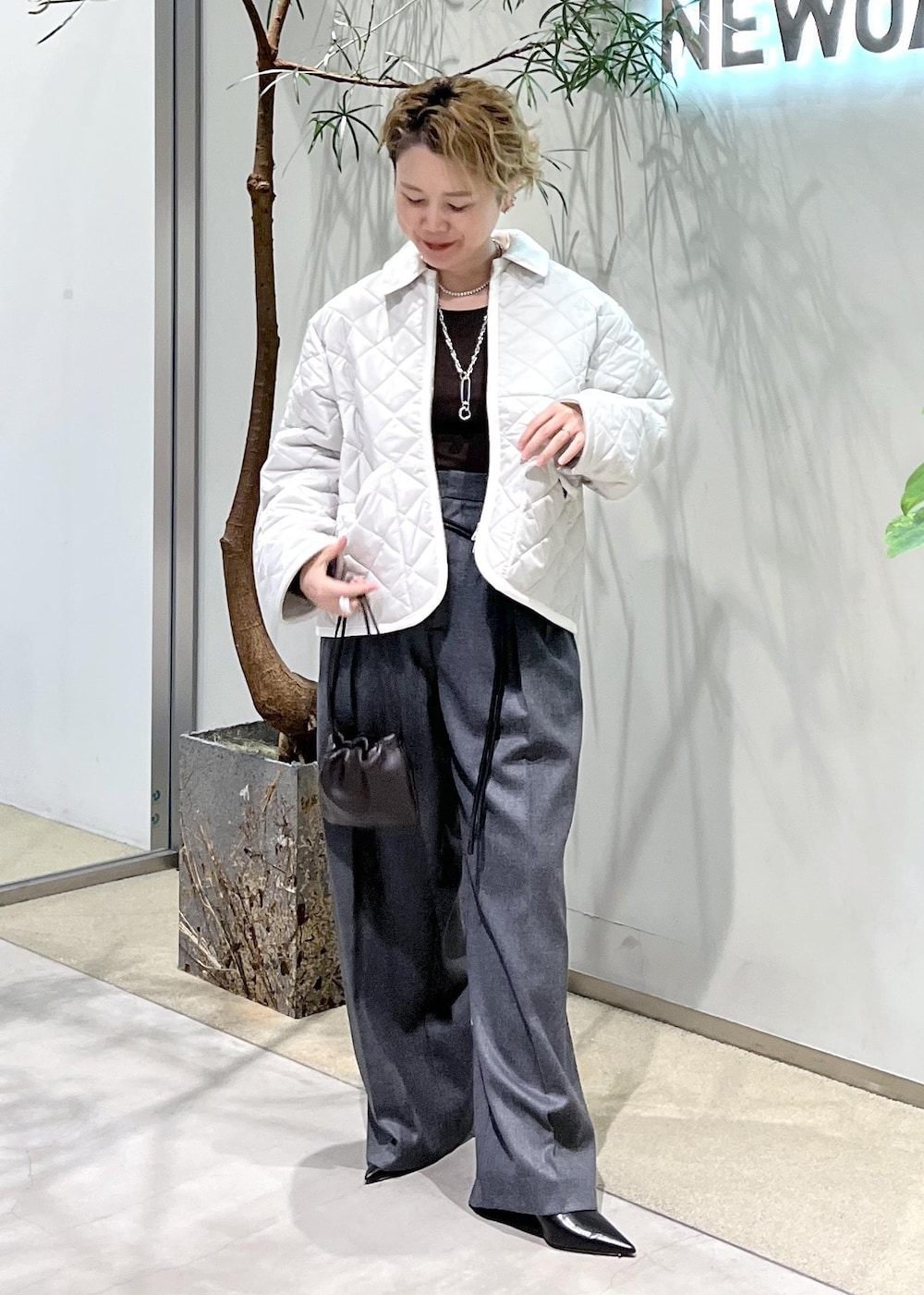 ピンク系のブルゾン、ブラウン系のハンドバッグ、ブラック系のパンプスを着用したレディースの秋コーディネートの4枚目の写真