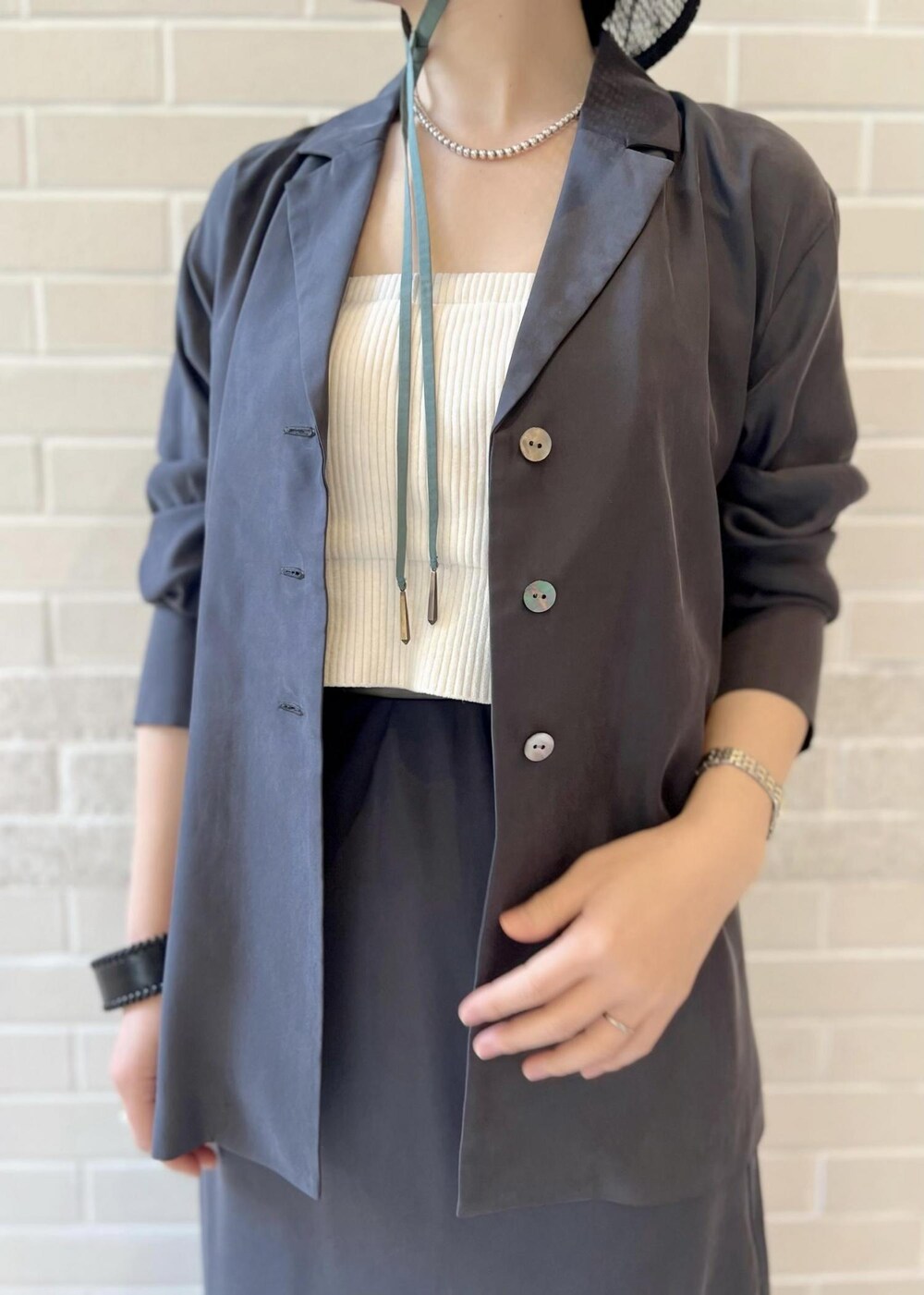 グレー系のスカート、グレー系のシャツ/ブラウス、ホワイト系のチューブトップを着用したレディースの春コーディネートの5枚目の写真