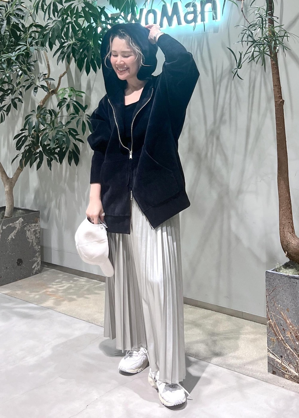 ベージュ系のスカート、ブラック系のタンクトップ、ブラック系のパーカーを着用したレディースの秋コーディネートの4枚目の写真