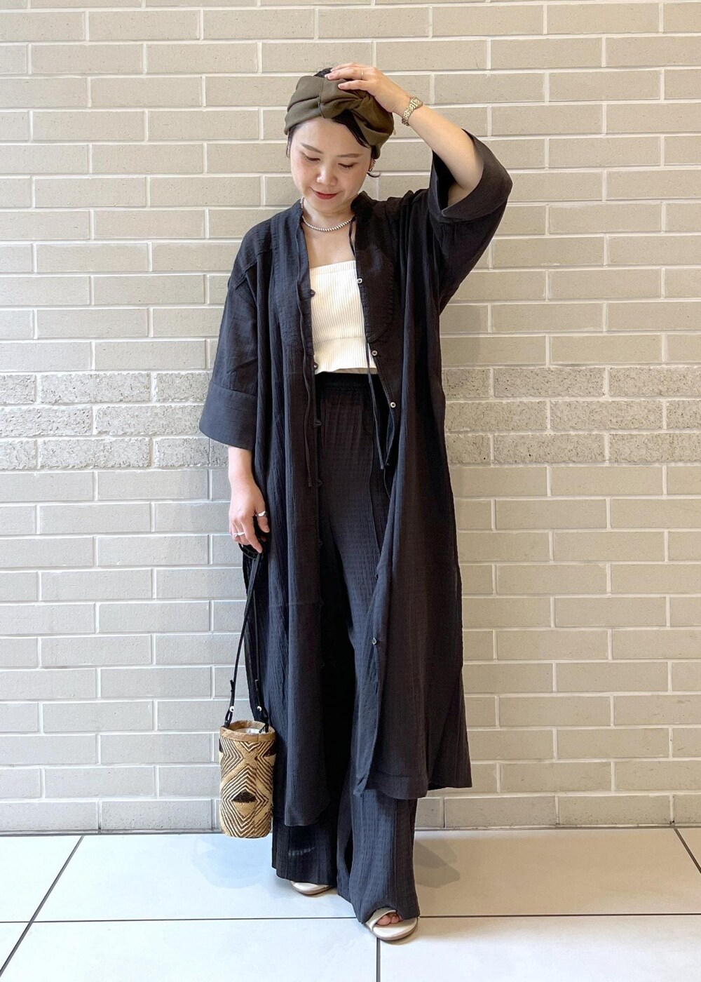 ホワイト系のチューブトップ、ベージュ系のサンダル、ブラック系のシャツ/ブラウスを着用したレディースの夏コーディネートの4枚目の写真