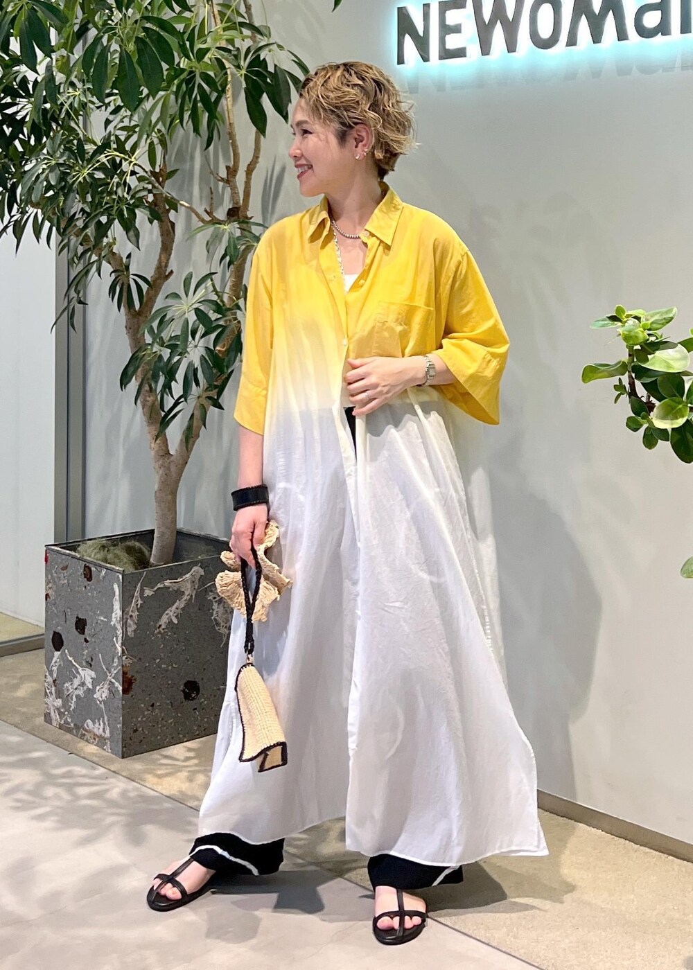 ブラック系のサンダル、ホワイト系のハンドバッグを着用したレディースの夏コーディネートの3枚目の写真