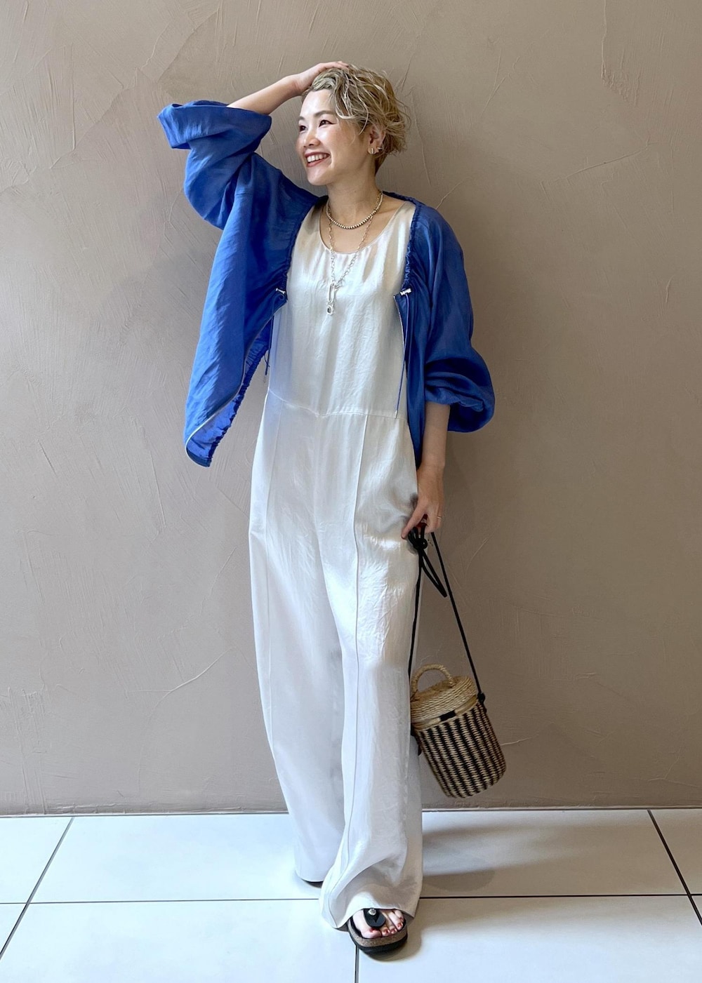ホワイト系のショルダーバッグ、ブルー系のブルゾン、ホワイト系のつなぎ/オールインワンを着用したレディースの夏コーディネートの3枚目の写真