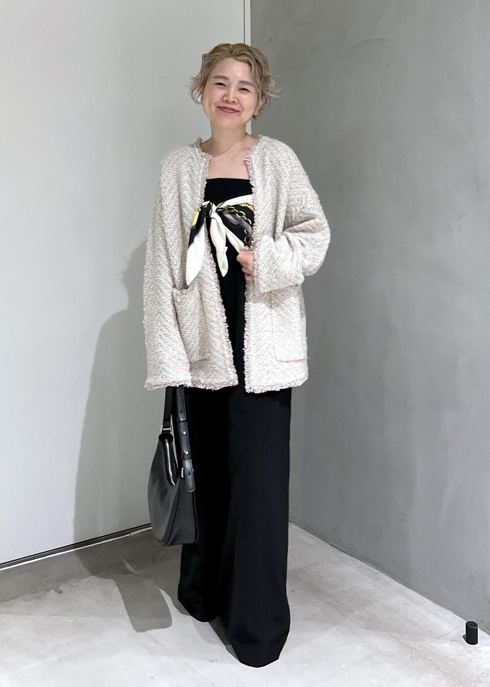 ブラック系のつなぎ/オールインワン、ベージュ系のカーディガン/ボレロ、ブラック系のブーツを着用したレディースの秋コーディネートの3枚目の写真