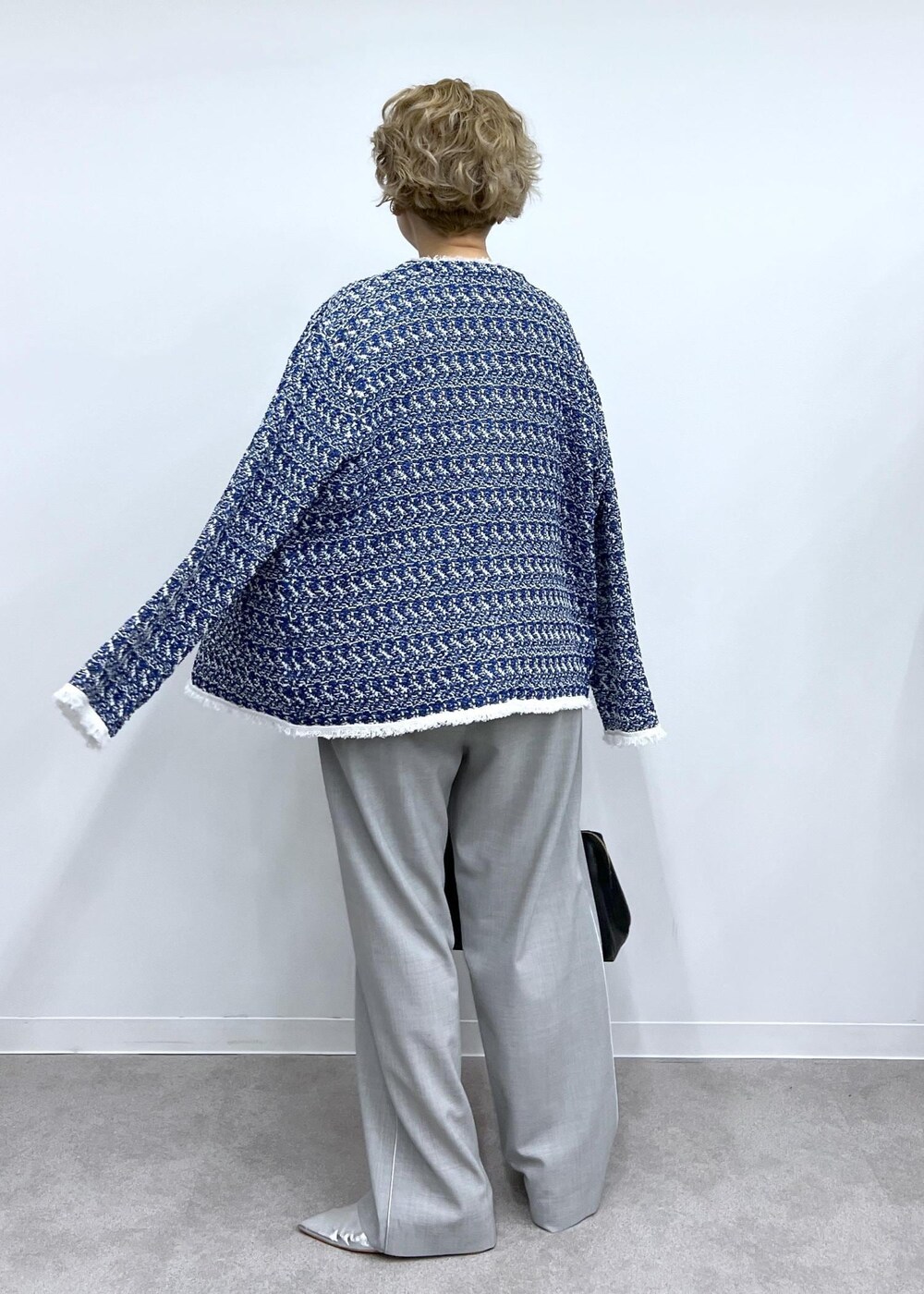 グレー系のベスト、グレー系のスラックス、シルバー系のパンプスを着用したレディースの春コーディネートの5枚目の写真