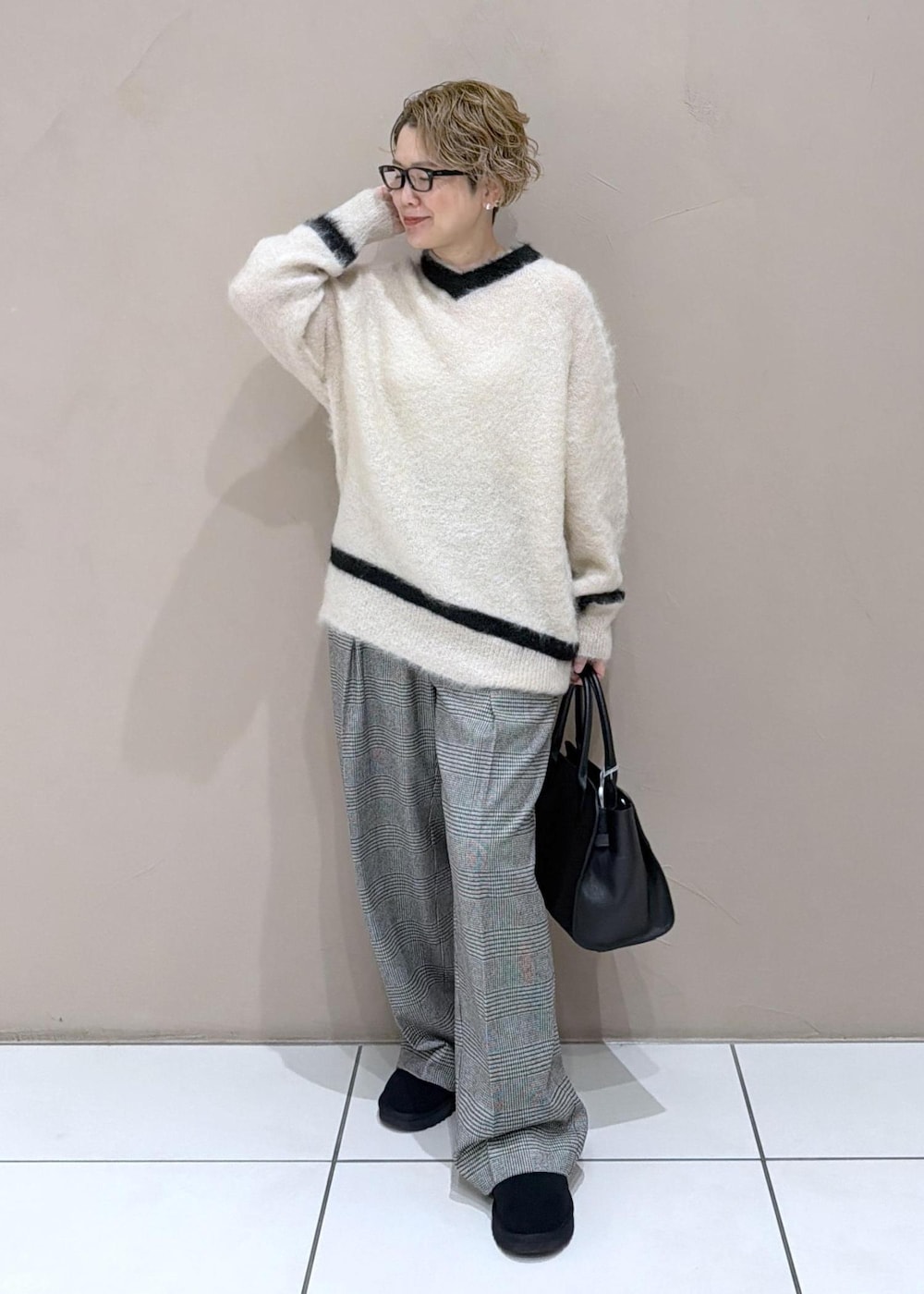 グレー系のスラックス、ブラック系のブーツを着用したレディースの冬コーディネートの4枚目の写真