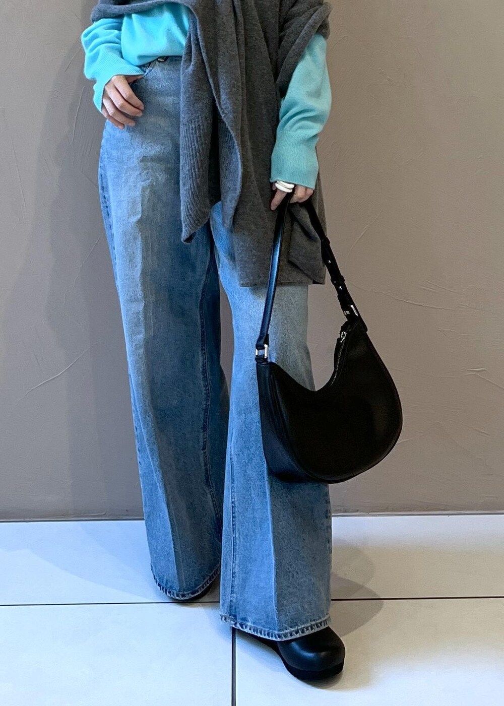 ブルー系のニット/セーター、ブルー系のデニムパンツ、ブラック系のスニーカーを着用したレディースの秋コーディネートの8枚目の写真