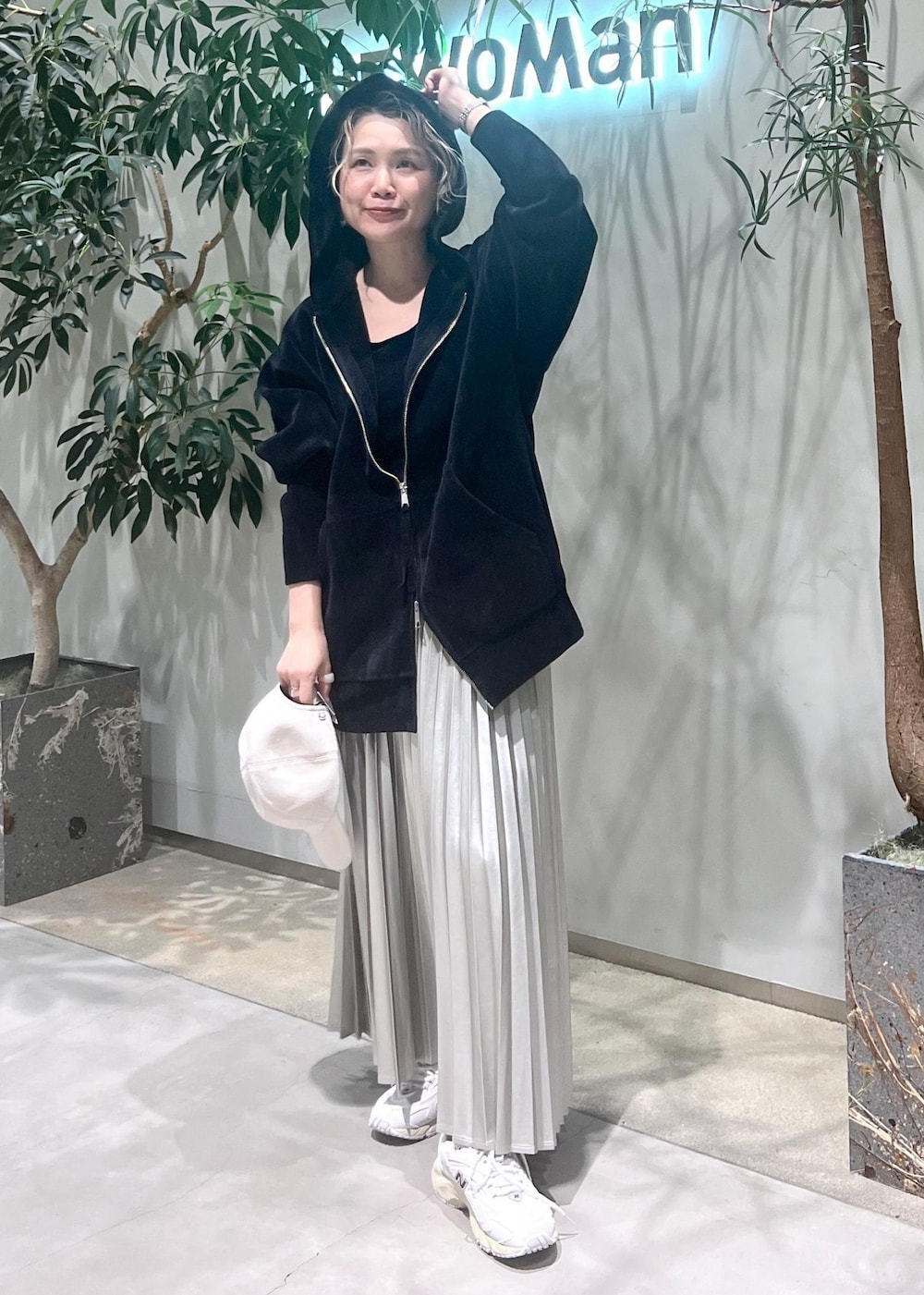 ベージュ系のスカート、ブラック系のタンクトップ、ブラック系のパーカーを着用したレディースの秋コーディネートの3枚目の写真