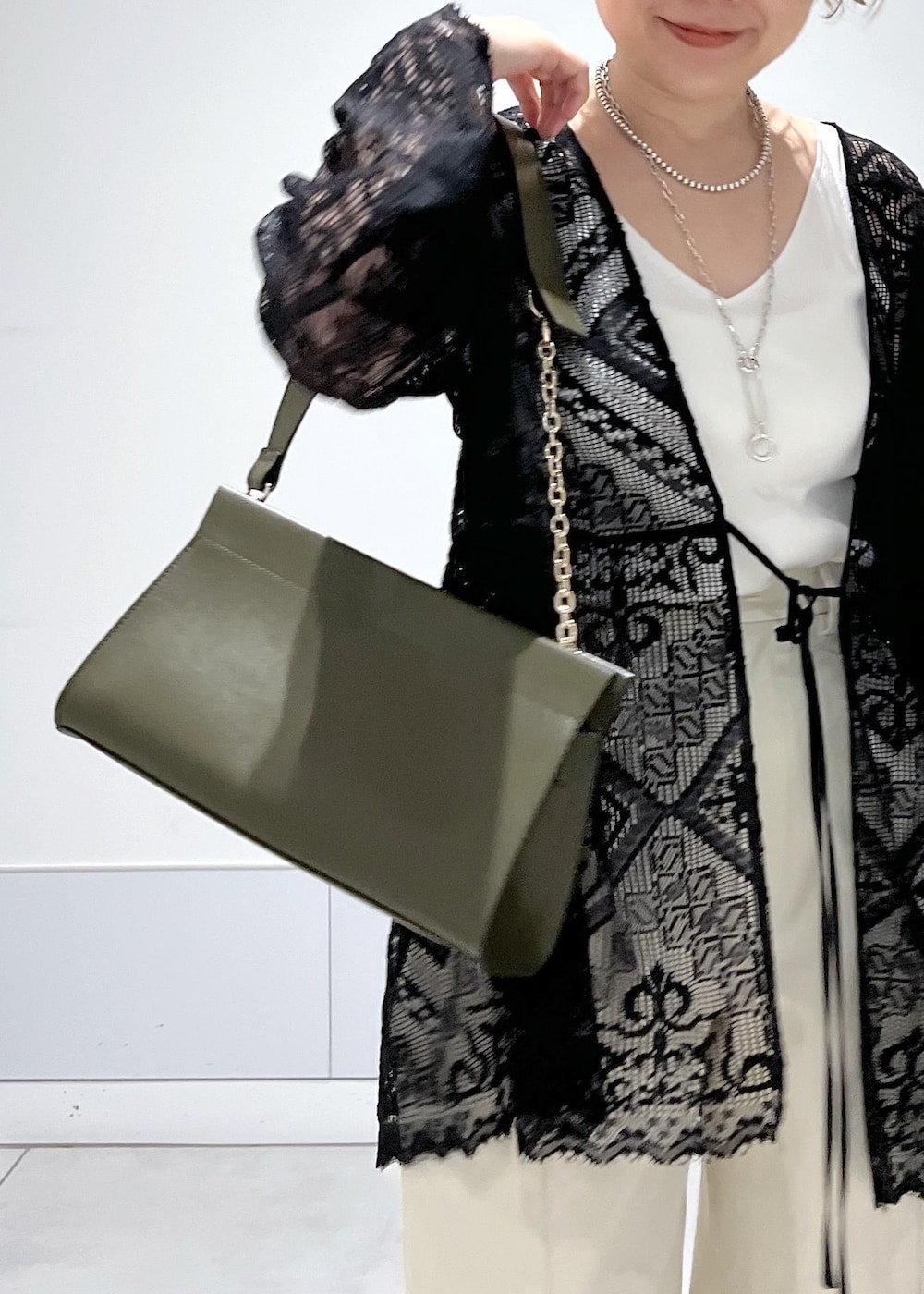 ホワイト系のカーゴパンツ、ホワイト系のキャミソール、ブラック系のノーカラージャケットを着用したレディースの夏コーディネートの7枚目の写真