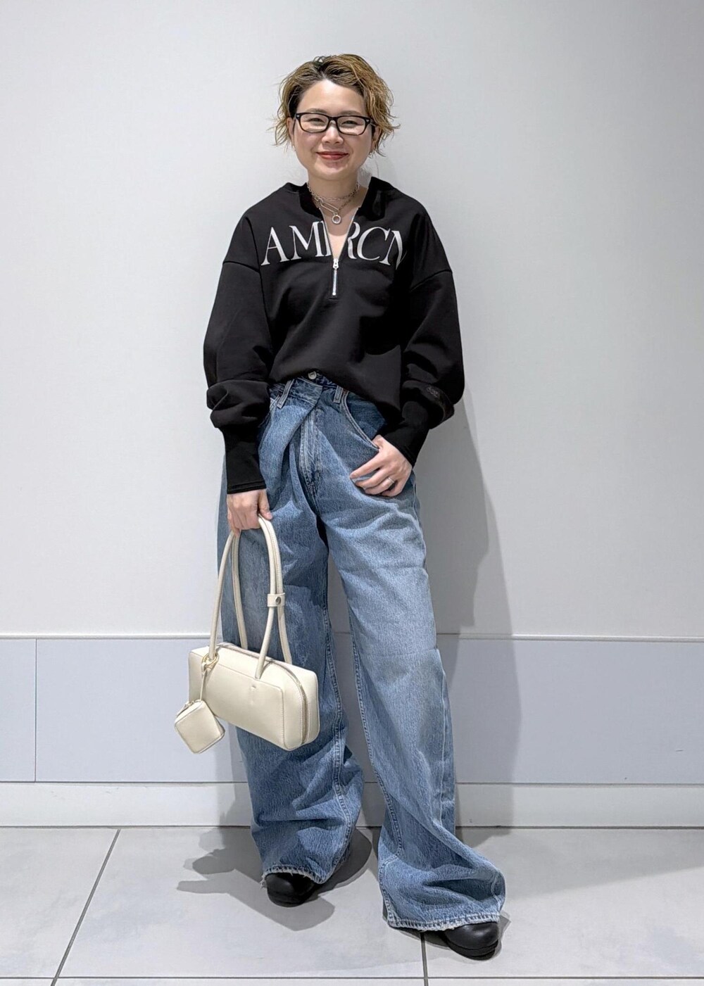 ブラック系のスウェット、ブルー系のデニムパンツを着用したレディースの冬コーディネートの3枚目の写真