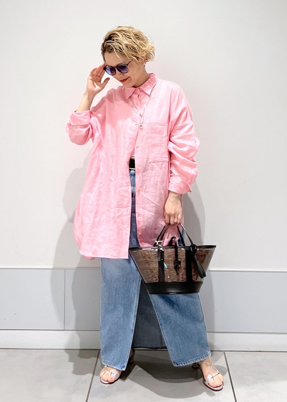 ピンク系のシャツ/ブラウス、ホワイト系のかごバッグ、ブルー系のデニムスカートを着用したレディースの春コーディネートの2枚目の写真