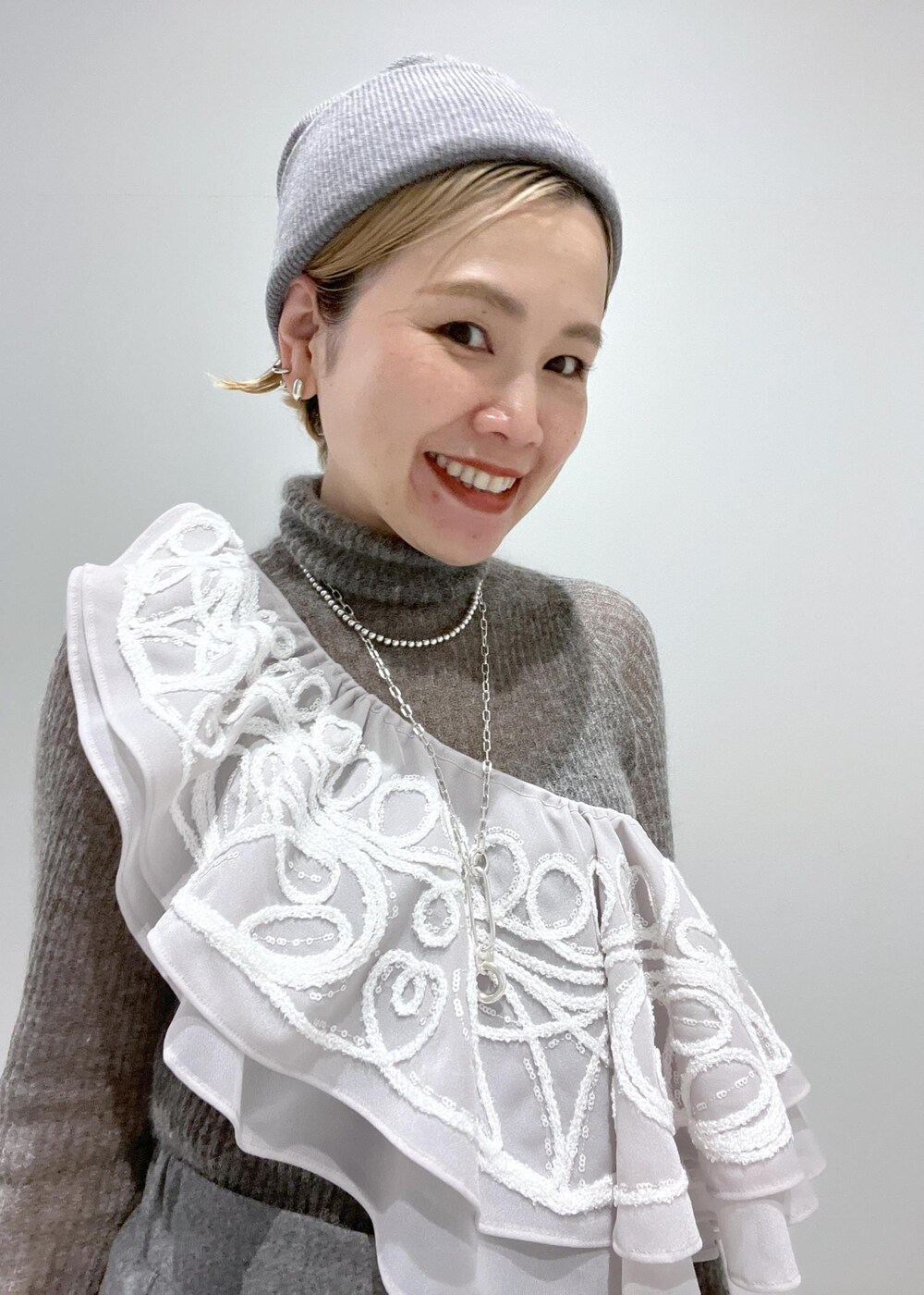 ブラック系のブーツ、グレー系のニット/セーター、ベージュ系のストール/ショールを着用したレディースの冬コーディネートの5枚目の写真