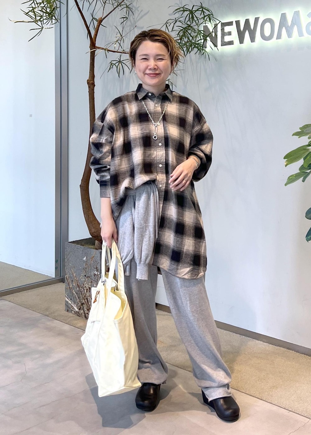 ブラック系のスニーカー、イエロー系のトートバッグを着用したレディースの秋コーディネートの3枚目の写真