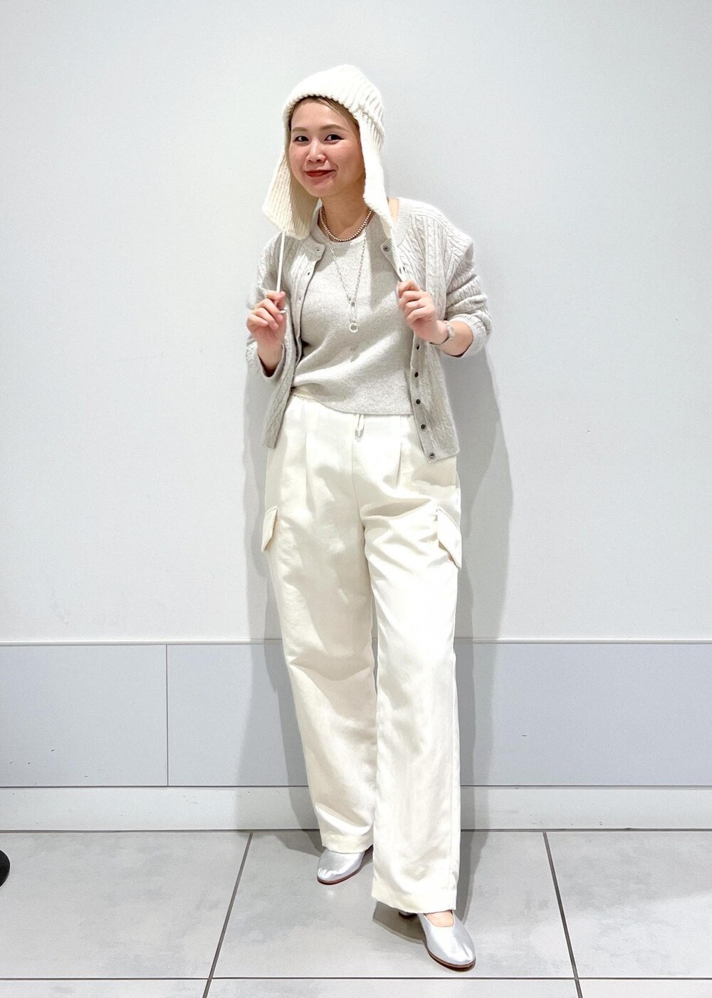ホワイト系のカーゴパンツ、ホワイト系のキャミソール、ホワイト系のカーディガン/ボレロを着用したレディースの冬コーディネートの4枚目の写真