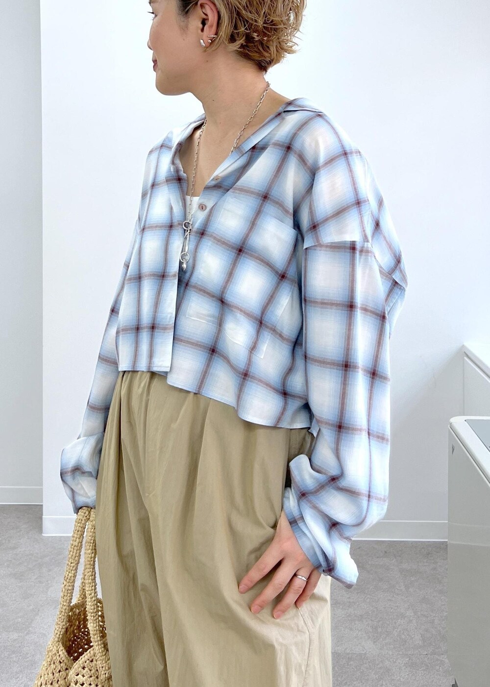 ホワイト系のかごバッグ、その他のサンダル、ベージュ系のその他パンツを着用したレディースの春コーディネートの6枚目の写真