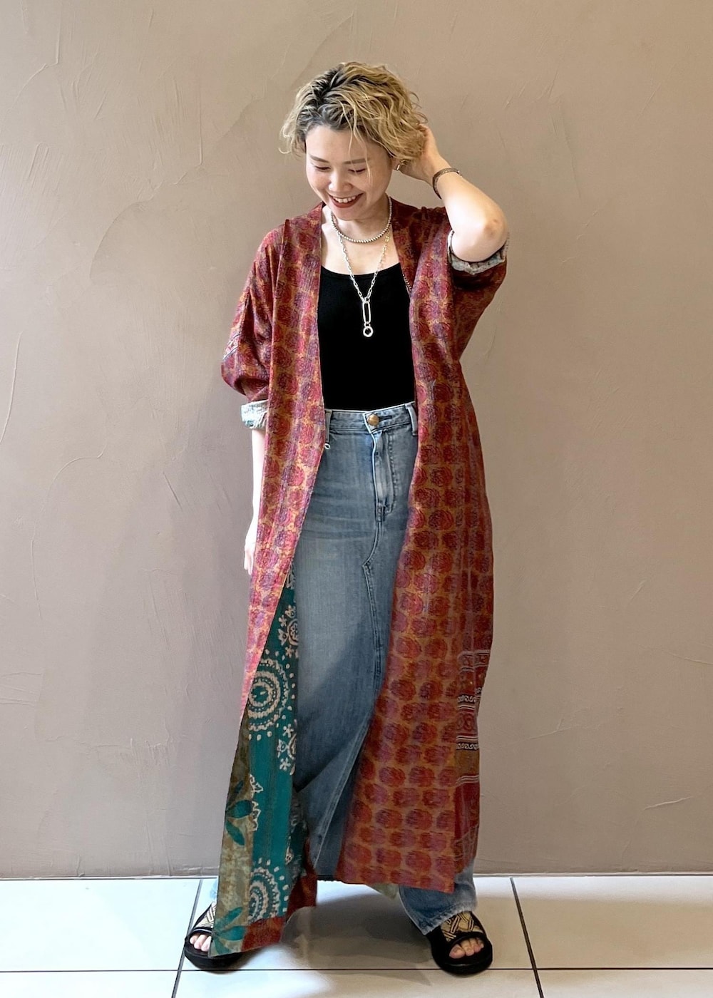 ブラック系のショルダーバッグ、ブラック系のタンクトップ、ブルー系のデニムスカートを着用したレディースの春コーディネートの3枚目の写真