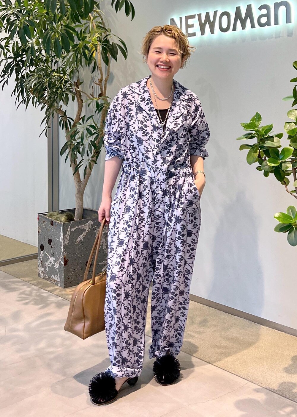 ブラウン系のボストンバッグ、ブラック系のサンダルを着用したレディースの夏コーディネートの3枚目の写真