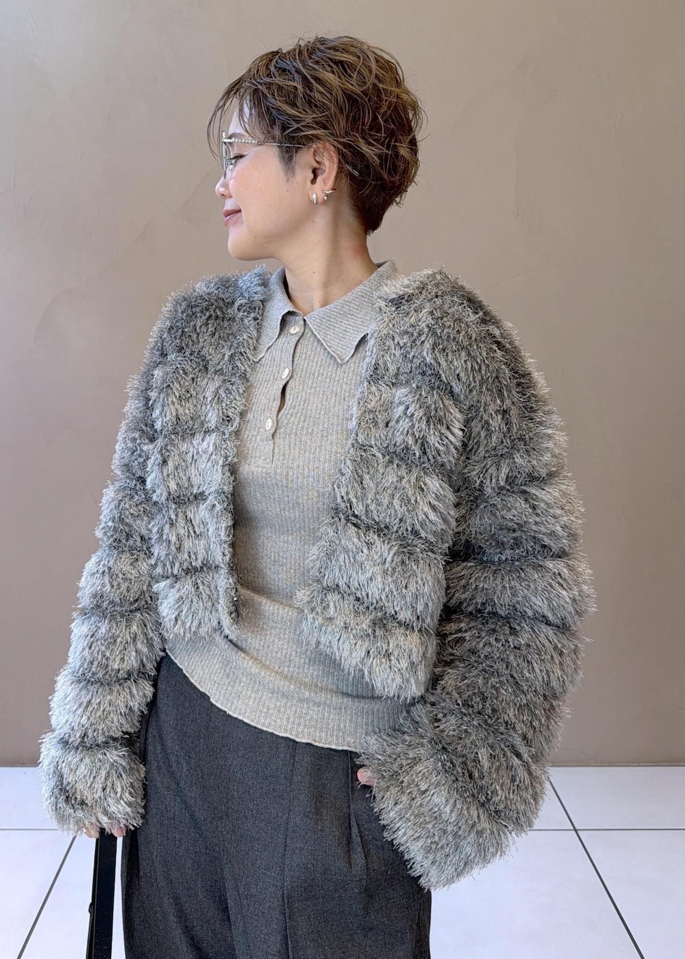 ブラック系のショルダーバッグ、グレー系のスラックス、グレー系のカーディガン/ボレロを着用したレディースの冬コーディネートの6枚目の写真