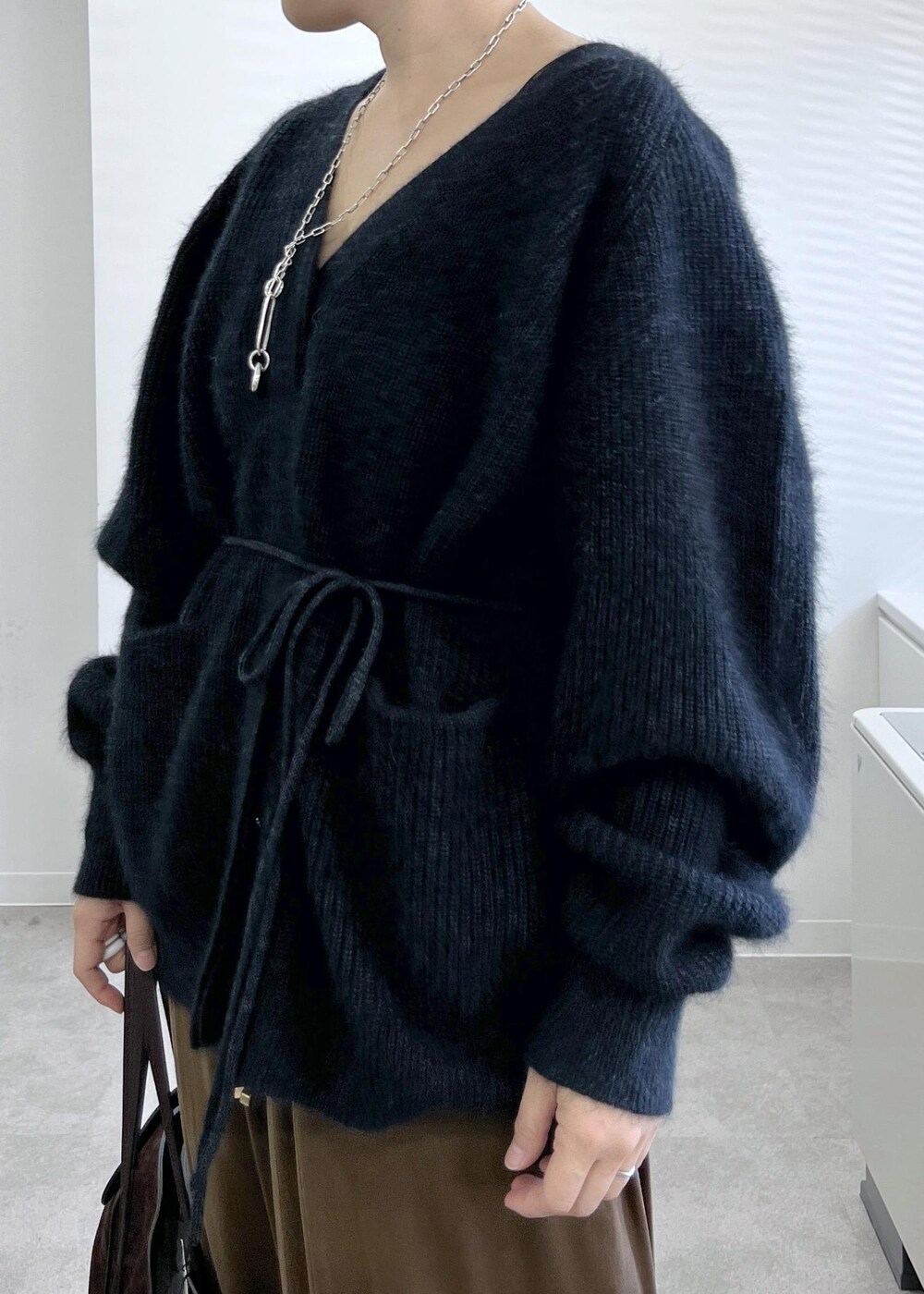 ブラック系のブーツ、ブラウン系のその他パンツ、グレー系のカーディガン/ボレロを着用したレディースの秋コーディネートの5枚目の写真
