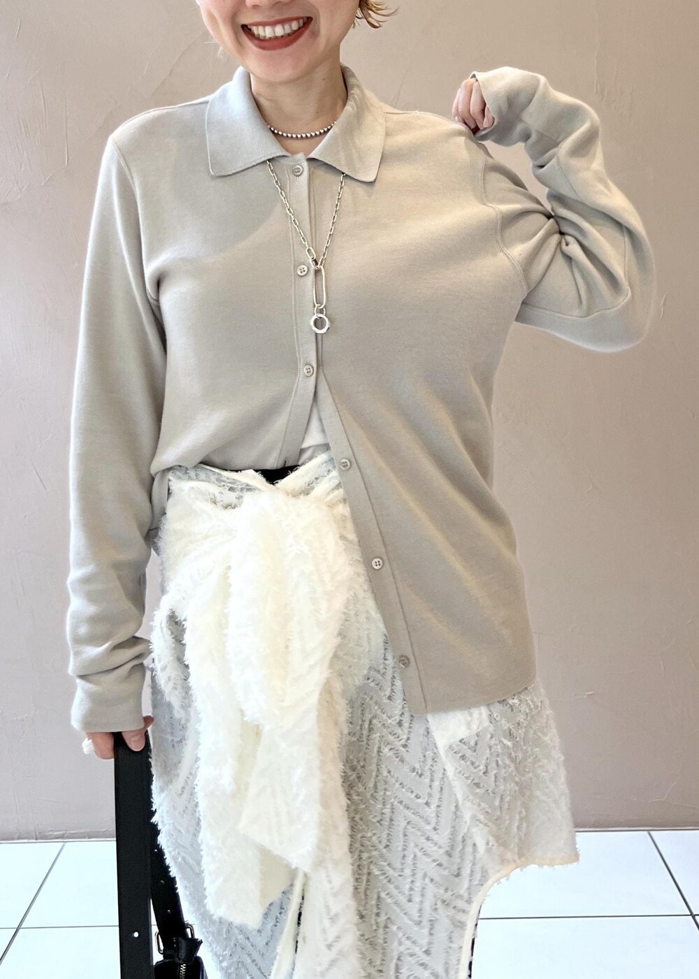 グレー系のカーディガン/ボレロ、ブラック系のショルダーバッグ、ホワイト系のシャツ/ブラウスを着用したレディースの秋コーディネートの6枚目の写真