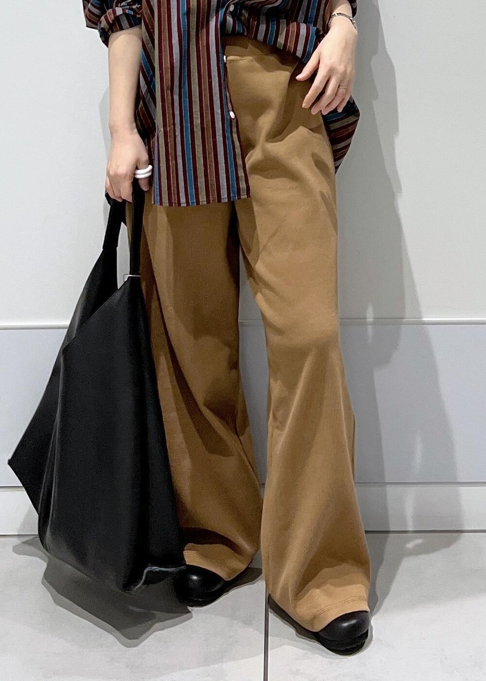 ブラック系のトートバッグ、ブラック系のスニーカー、ブラウン系のその他パンツを着用したレディースの冬コーディネートの7枚目の写真