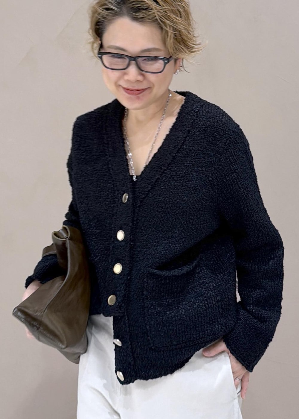 ブラック系のカーディガン/ボレロ、ホワイト系のサロペット/オーバーオール、ブラック系のローファーを着用したレディースの冬コーディネートの6枚目の写真