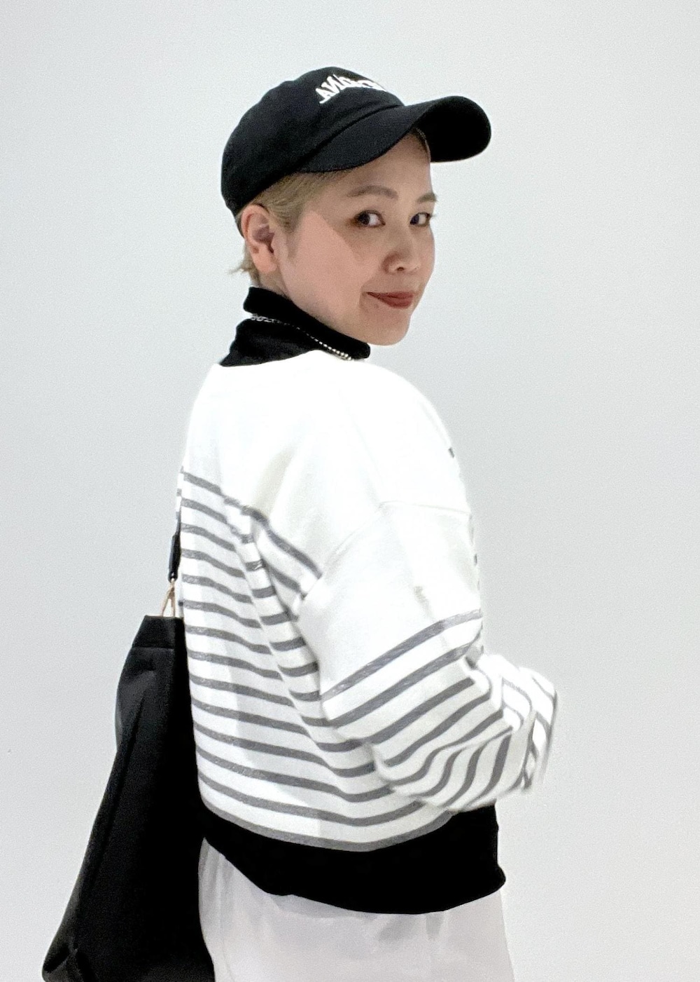 ブラック系のブーツ、ブラック系のTシャツ/カットソー、シルバー系のスカートを着用したレディースの冬コーディネートの8枚目の写真