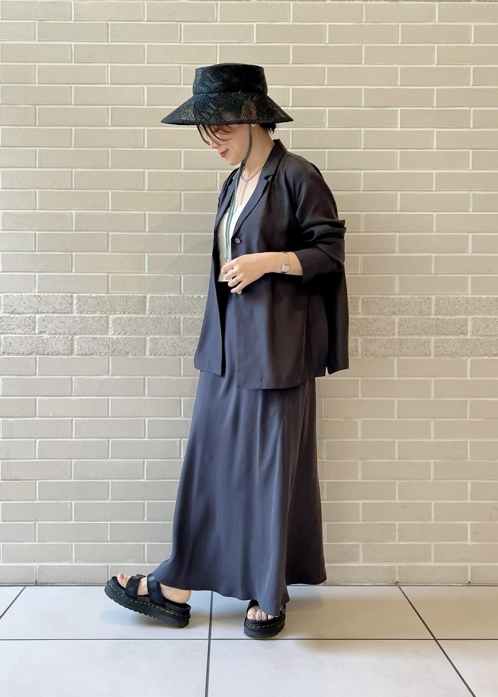 グレー系のスカート、グレー系のシャツ/ブラウス、ホワイト系のチューブトップを着用したレディースの春コーディネートの2枚目の写真