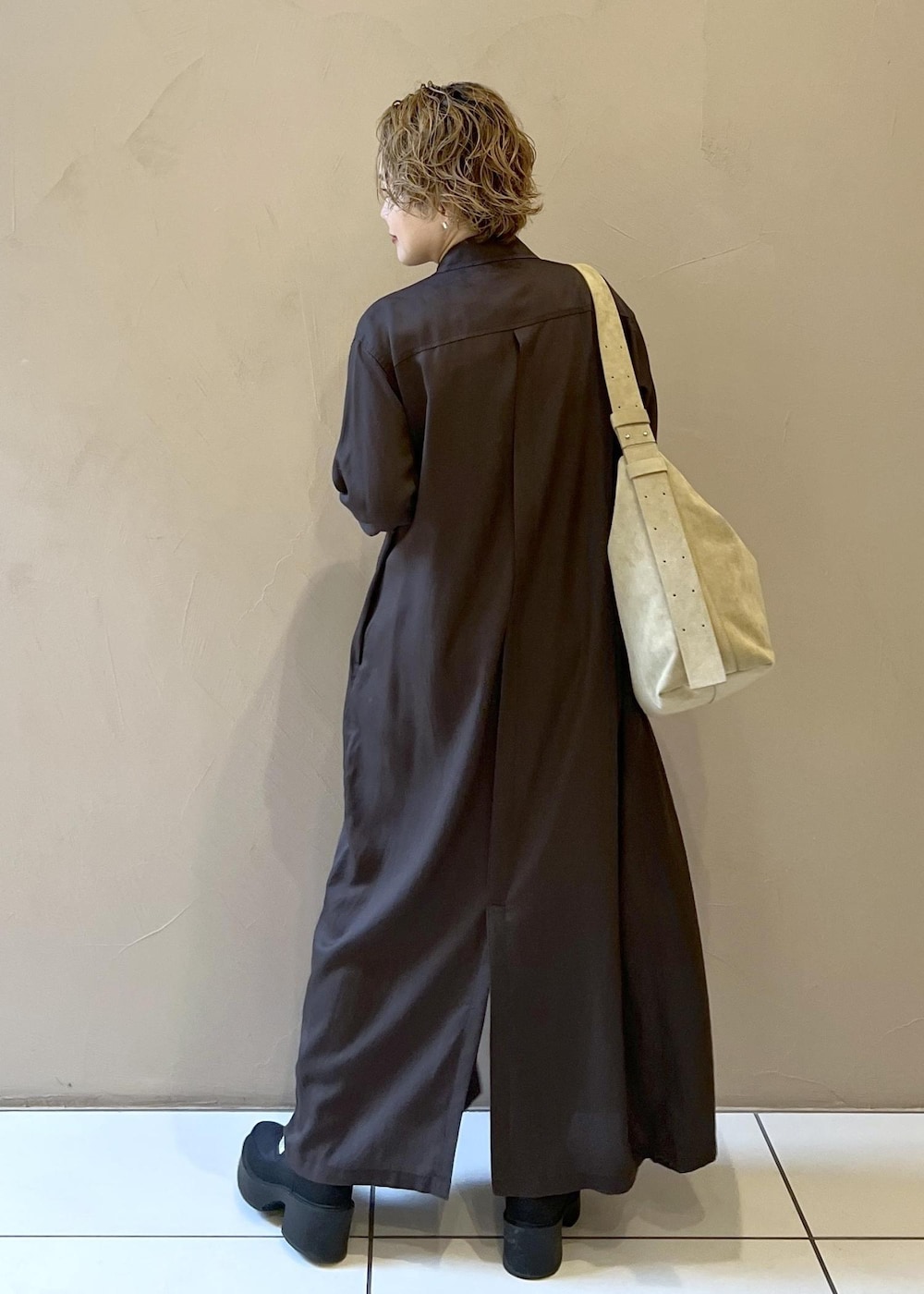 ベージュ系のショルダーバッグ、グレー系のワンピース、ブラック系のブーツを着用したレディースの秋コーディネートの6枚目の写真