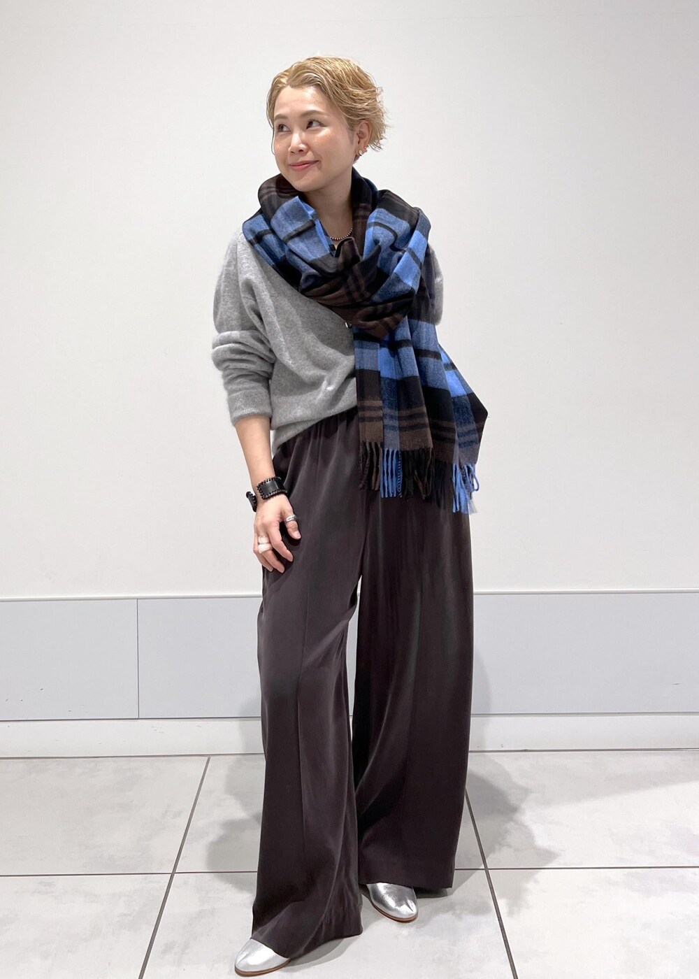 グレー系のその他パンツ、シルバー系のパンプス、その他のネックレスを着用したレディースの秋コーディネートの2枚目の写真