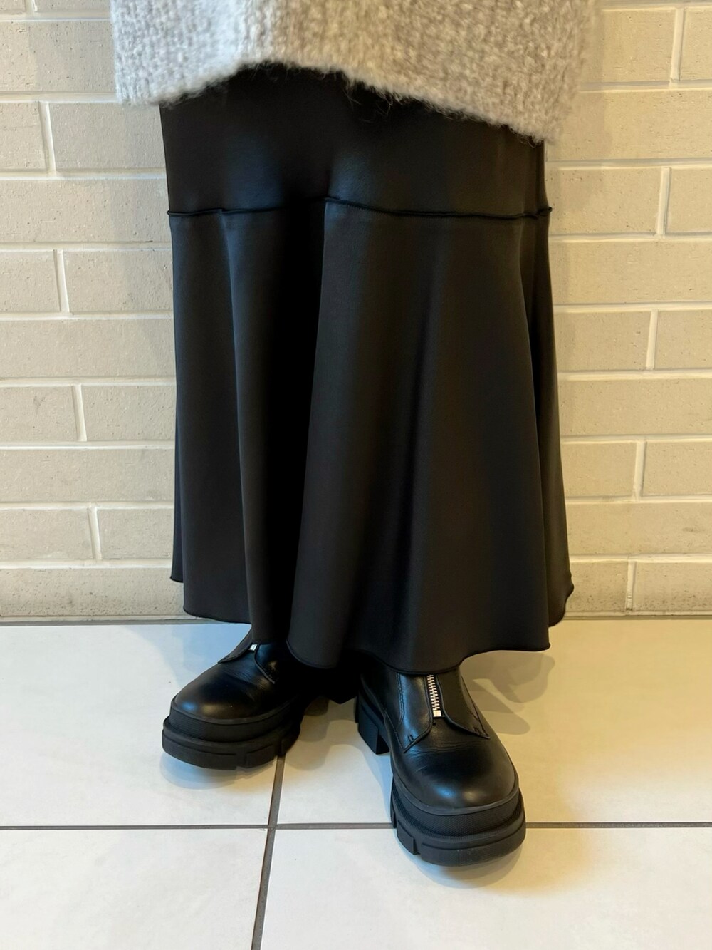 グレー系のニット/セーター、ブラック系のTシャツ/カットソー、ブラック系のスカートを着用したレディースの秋コーディネートの5枚目の写真