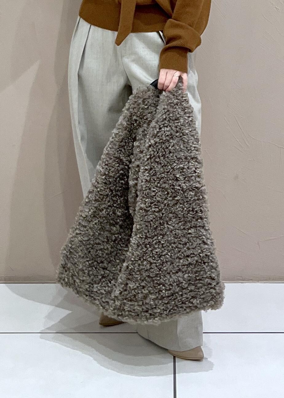 ベージュ系のスラックス、ブラウン系のトートバッグ、イエロー系のニット/セーターを着用したレディースの秋コーディネートの9枚目の写真