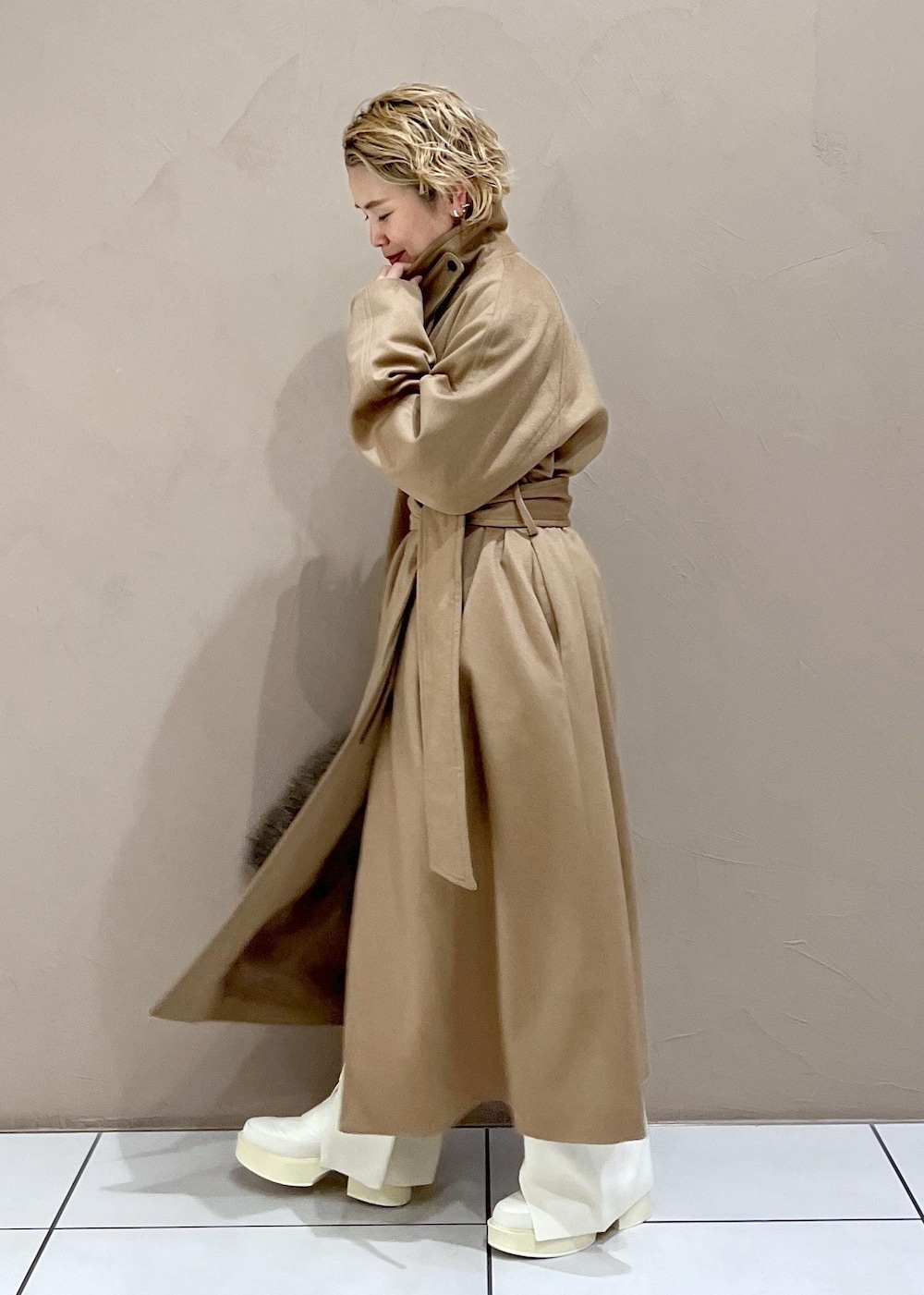 ブラウン系のハンドバッグ、ホワイト系のTシャツ/カットソー、イエロー系のステンカラーコートを着用したレディースの冬コーディネートの5枚目の写真