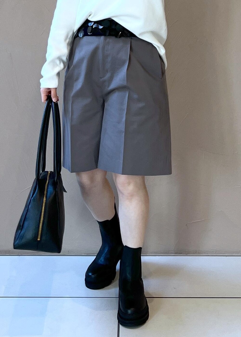 ブラック系のブーツ、ホワイト系のニット/セーター、グレー系のその他パンツを着用したレディースの冬コーディネートの7枚目の写真