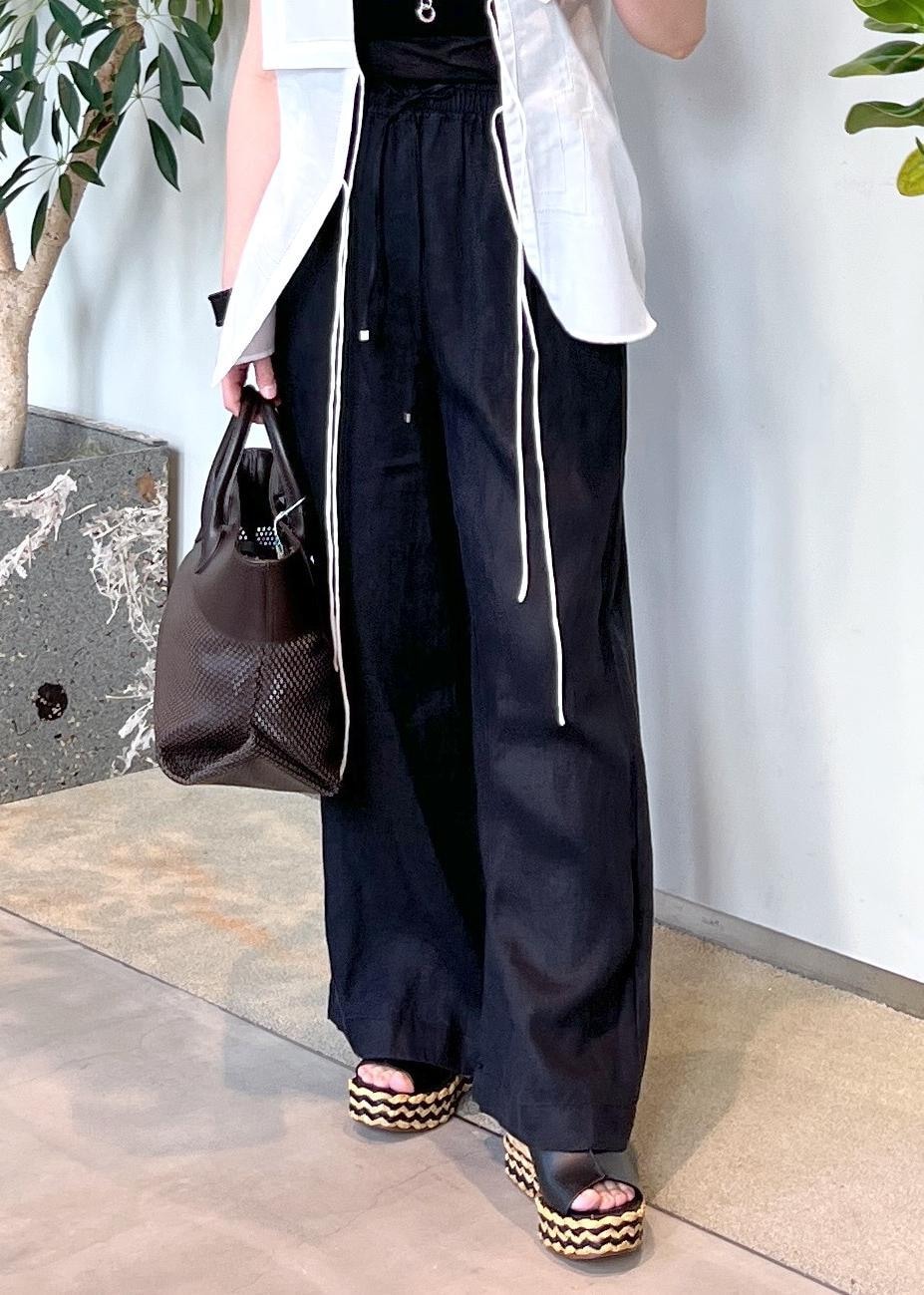 ブラック系のその他パンツ、ブラウン系のトートバッグ、ホワイト系のシャツ/ブラウスを着用したレディースの夏コーディネートの8枚目の写真