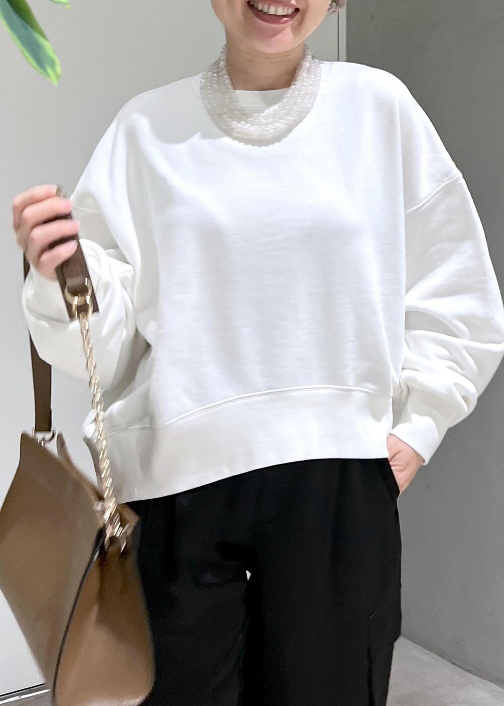 ホワイト系のスウェット、ブラック系のカーゴパンツ、ブラウン系のショルダーバッグを着用したレディースの秋コーディネートの7枚目の写真