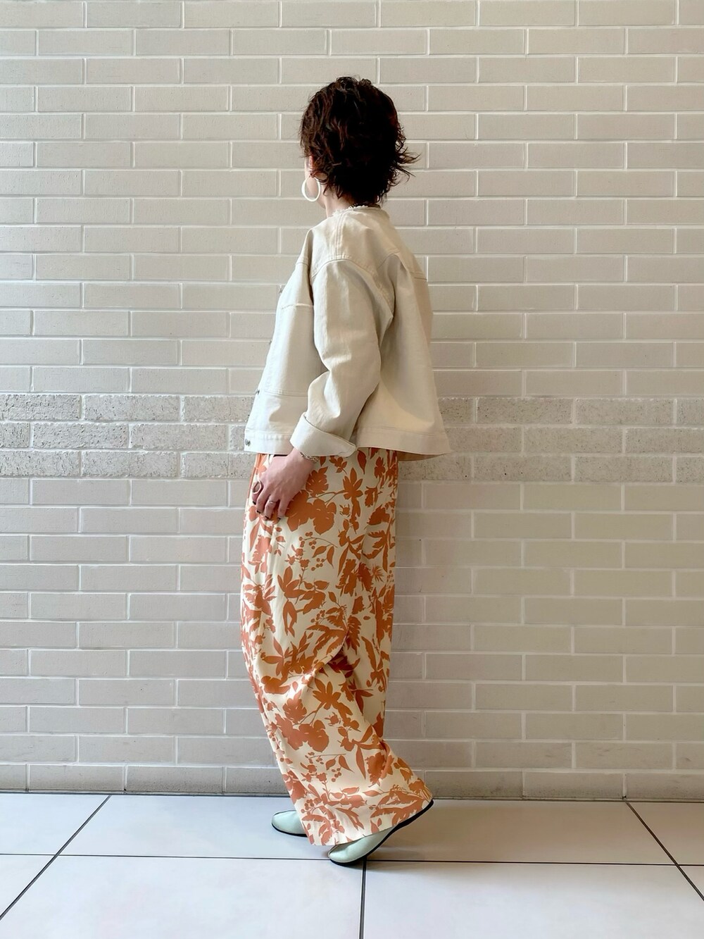 ホワイト系のブルゾン、グレー系のTシャツ/カットソー、オレンジ系のその他パンツを着用したレディースの春コーディネートの2枚目の写真