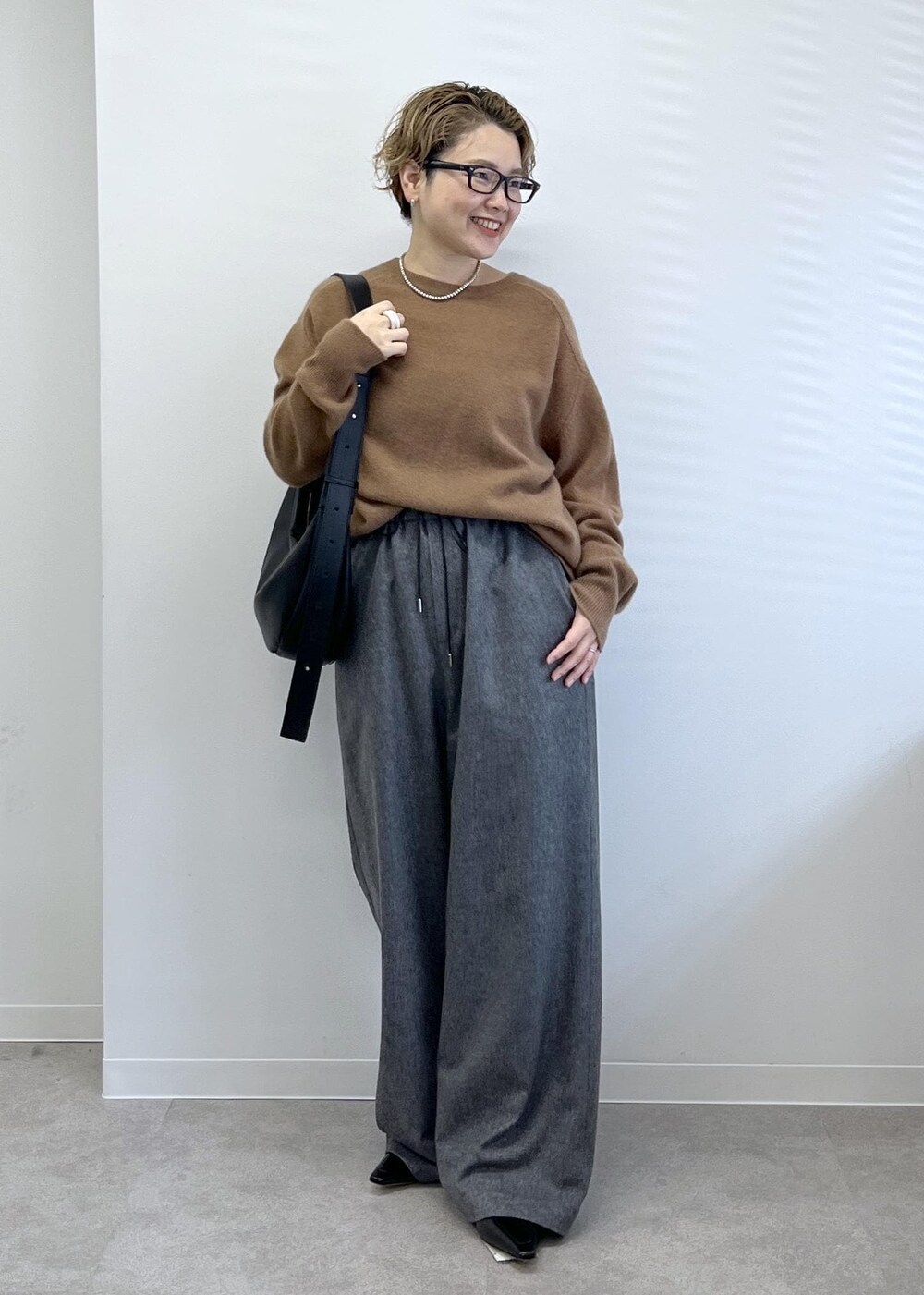 ブラック系のショルダーバッグ、グレー系のその他パンツ、ブラウン系のニット/セーターを着用したレディースの秋コーディネートの3枚目の写真